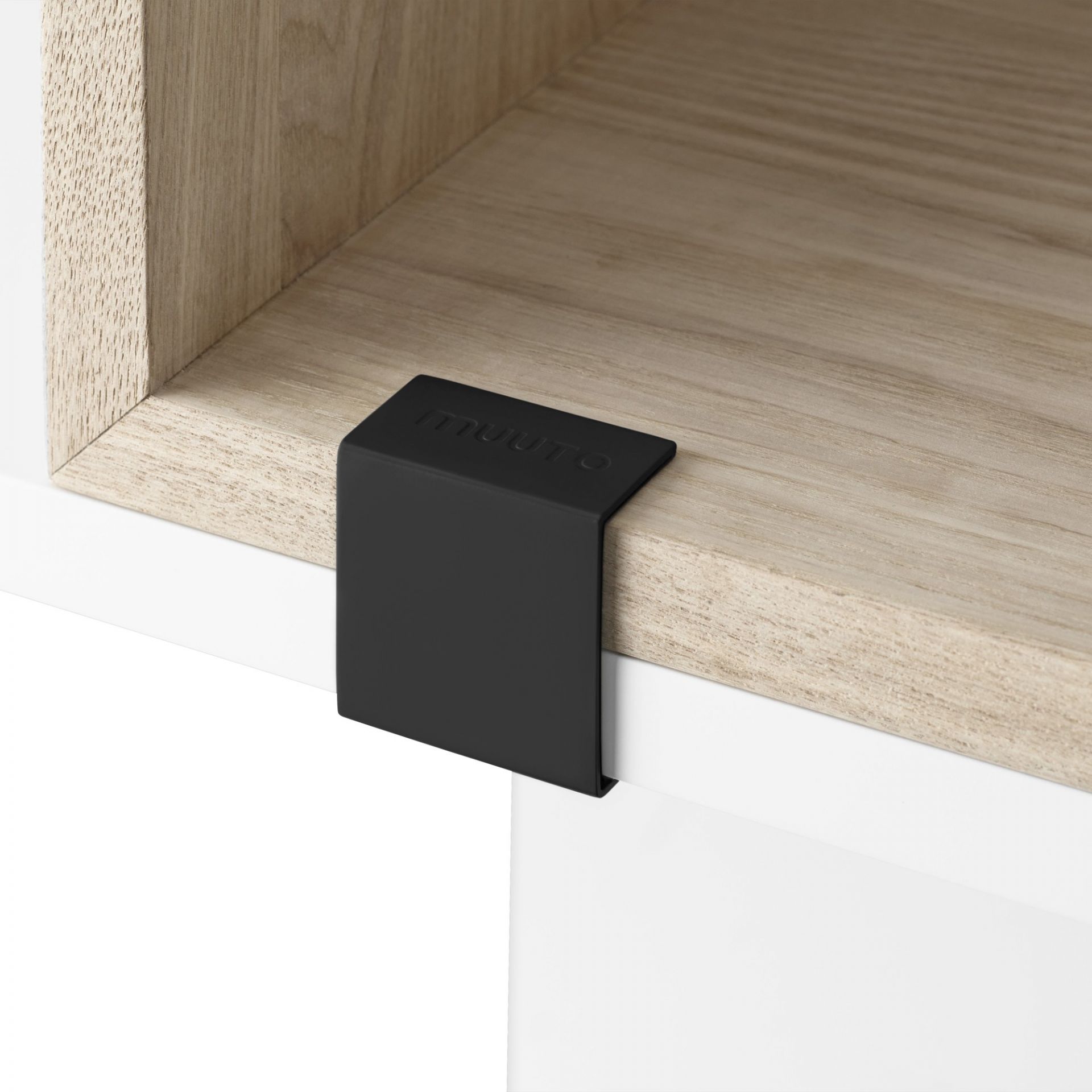 Detailaufnahme des Muuto Stacked Storage System 2.0 Regalsystems mit schwarzer Verbindungsspange und hellem Holzregal.
