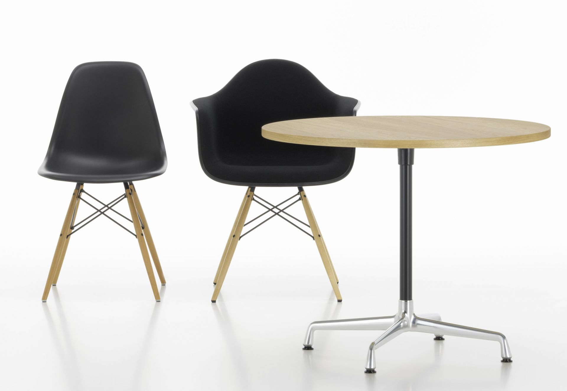 Eames Contract Table von Vitra mit zwei schwarzen Eames Stühlen auf weißem Hintergrund.