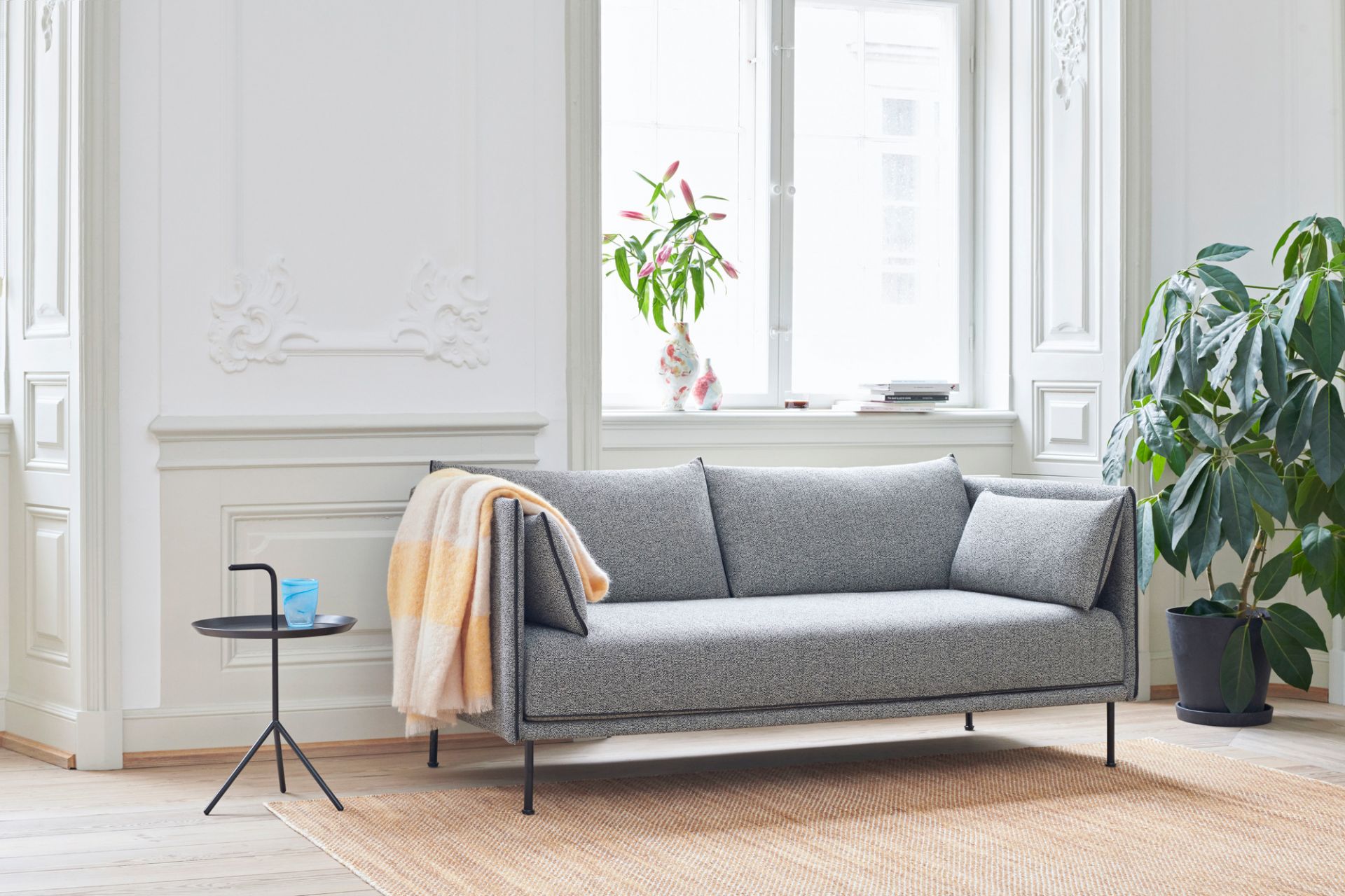 DLM Beistelltisch von Hay neben einem grauen Sofa in einem hellen Wohnzimmer. Moderner skandinavischer Stil.