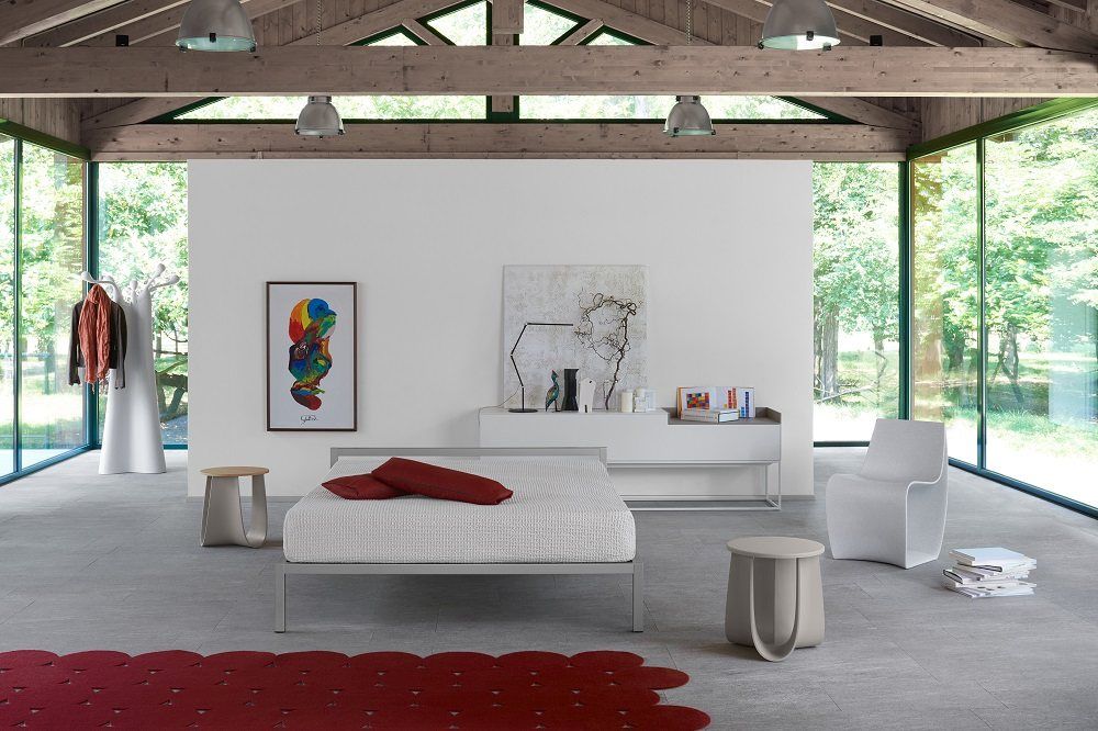 Helles Schlafzimmer mit MDF Italia Aluminium Bed Bett, Beistelltischen, Teppich und Kunst.