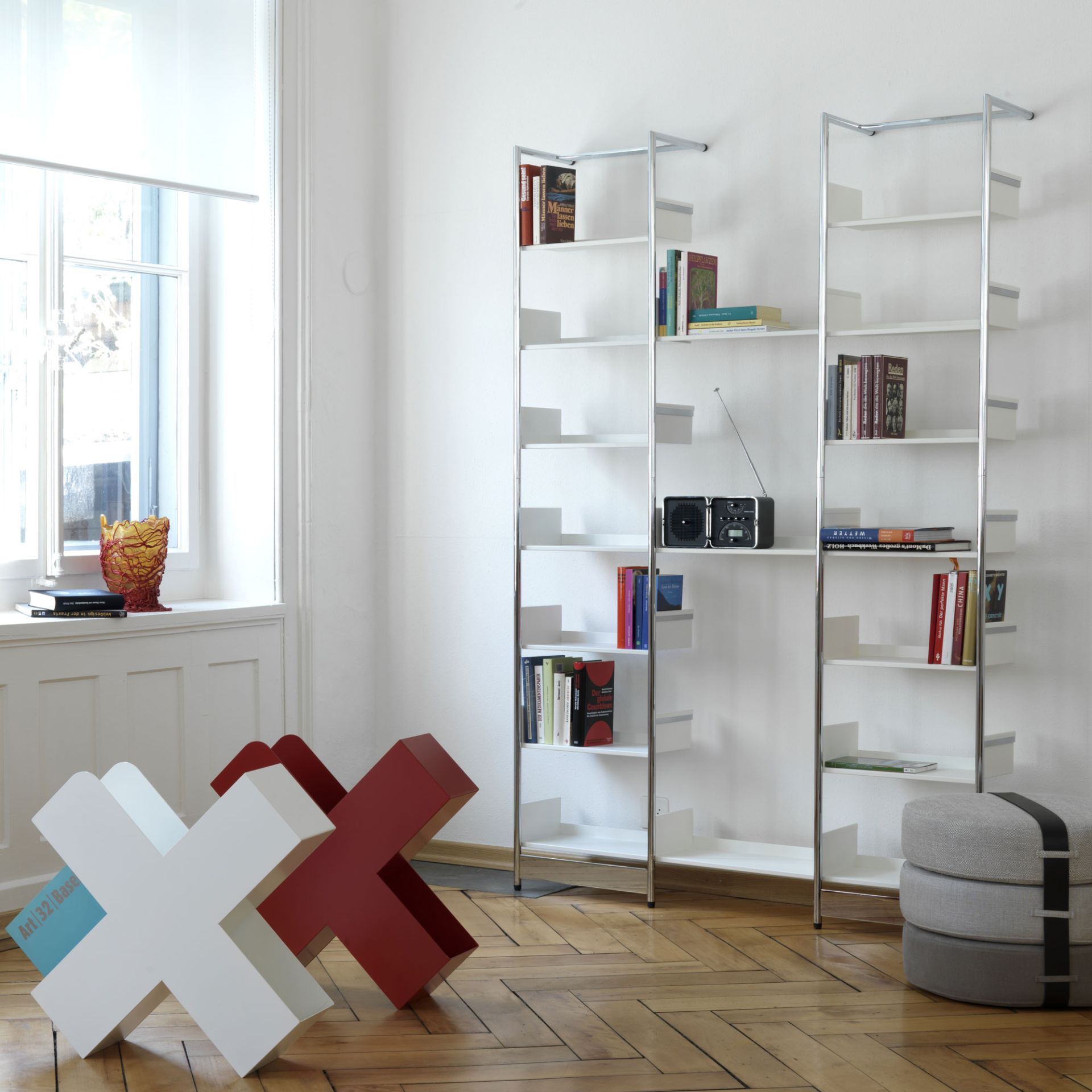 Pool 196 Medium Anlehnregal von Mox, modernes, weißes Bücherregal mit Chromgestell im Wohnzimmer.