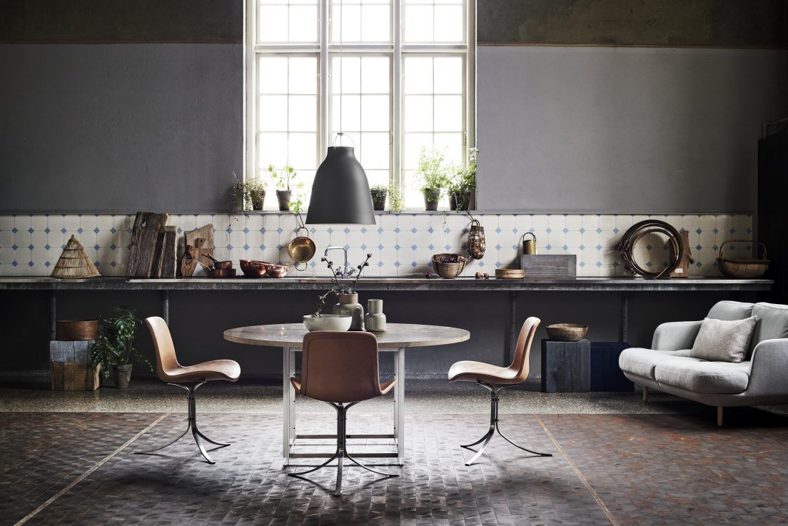 Schwarze Caravaggio Pendelleuchte von Fritz Hansen über einem Esstisch in einem modern eingerichteten Esszimmer.