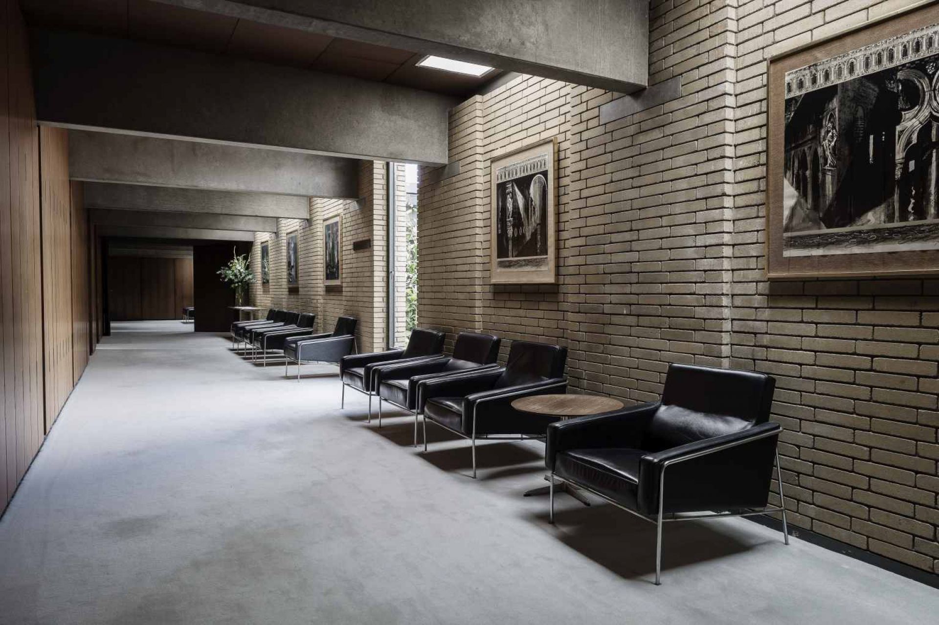 Reihe schwarzer Ledersessel, möglicherweise Serie 3300 von Fritz Hansen, in modernem Interieur.