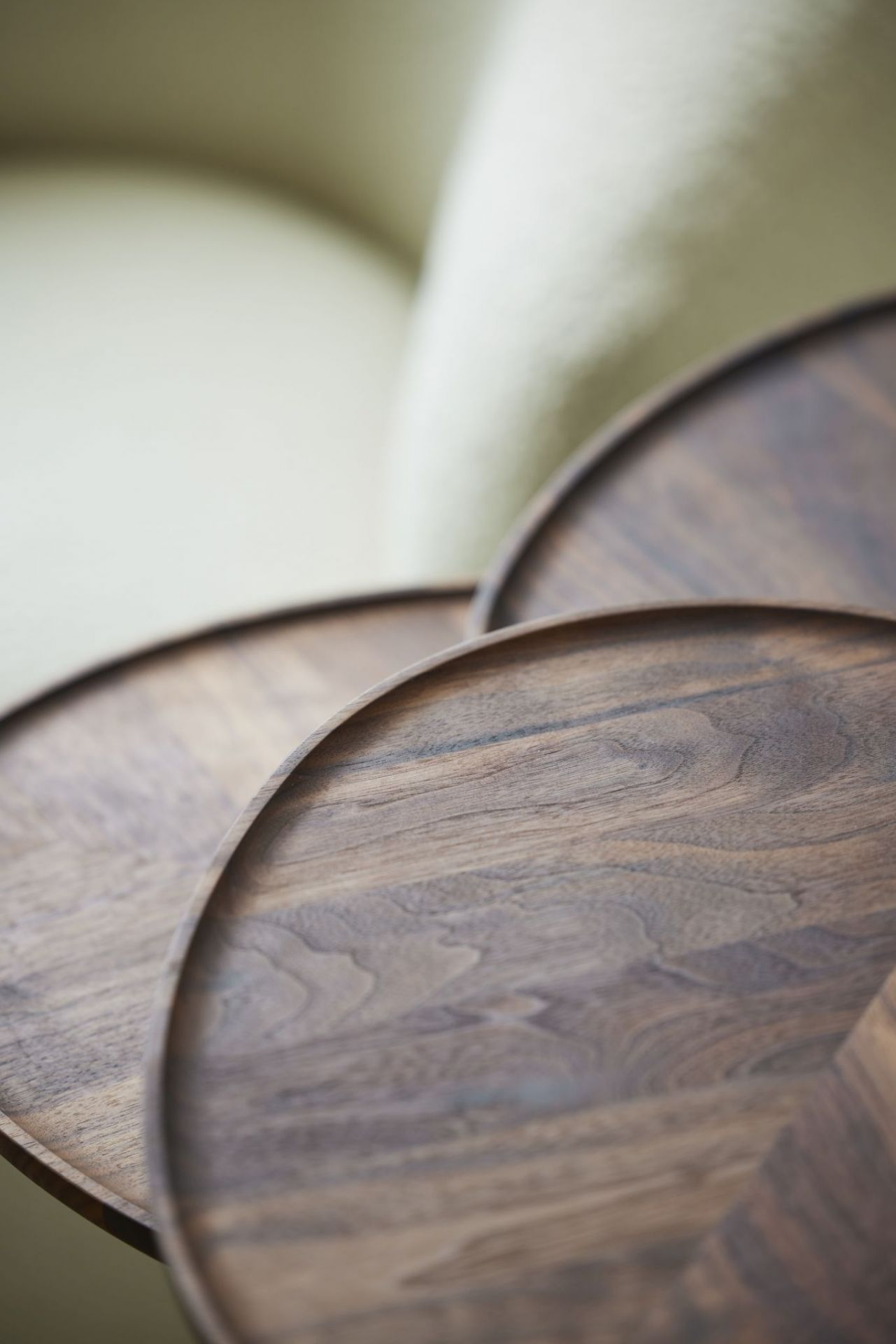 Detailaufnahme von drei PER/USE Leaf Beistelltischen aus dunklem Holz, die sich überlappen und eine organische Form bilden.
