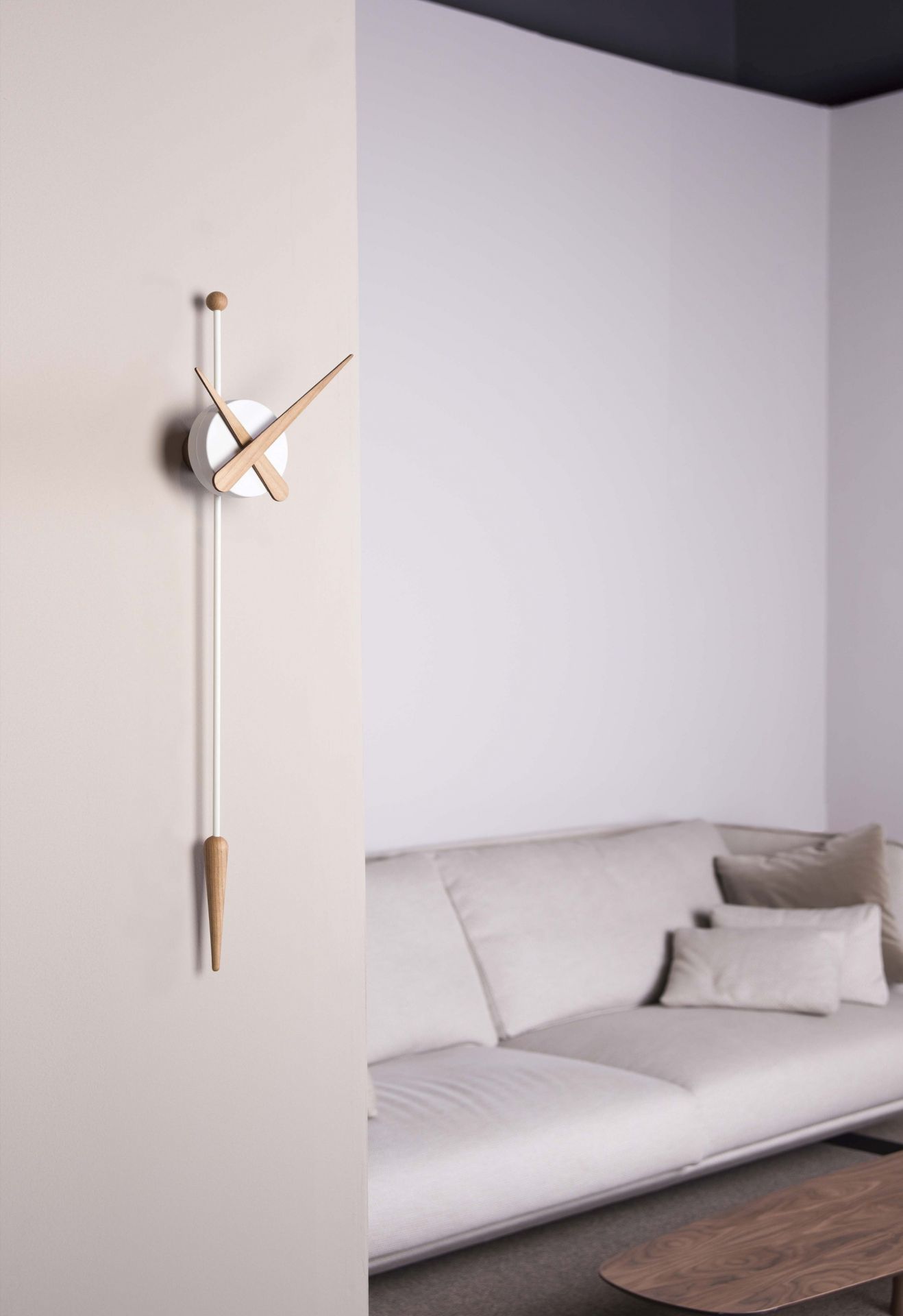 Weiße Wanduhr mit Eichenholz-Akzenten, Modell Punta von Nomon, modernes Design für Wohnzimmer.