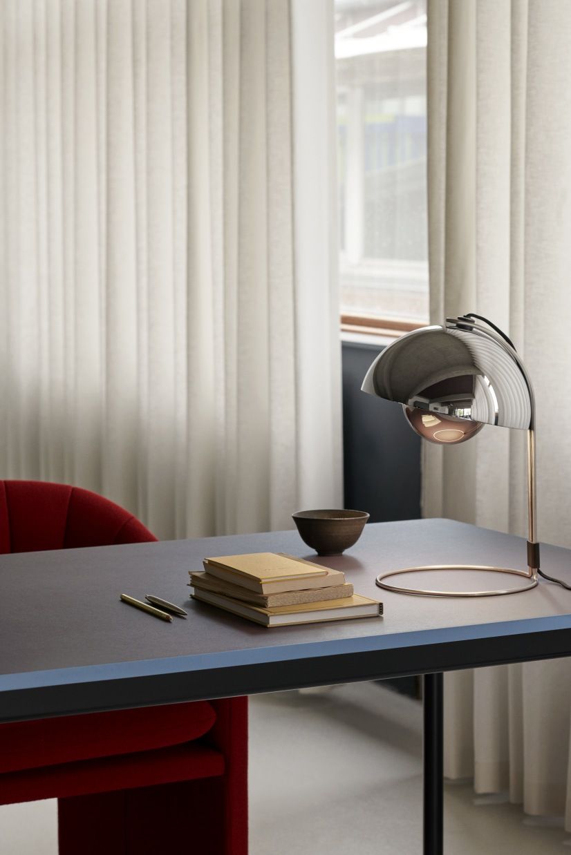 AndTradition Drip Table HW58 mit Lampe, Büchern und Schale auf einem modernen Schreibtisch.