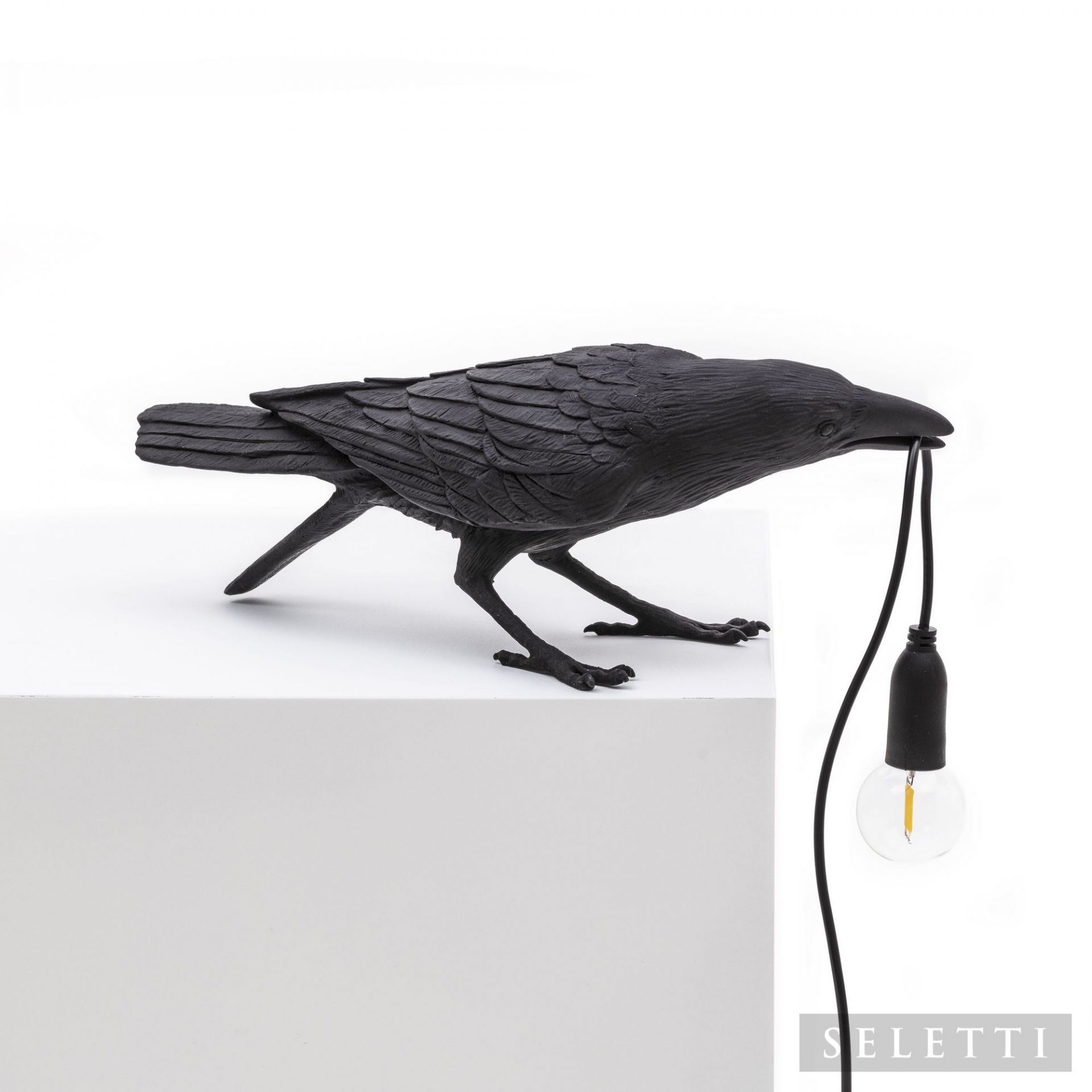Schwarze Bird Lamp Playing Leuchte von Seletti: Dekorative Tischleuchte in Form eines Raben mit Glühbirne im Schnabel.