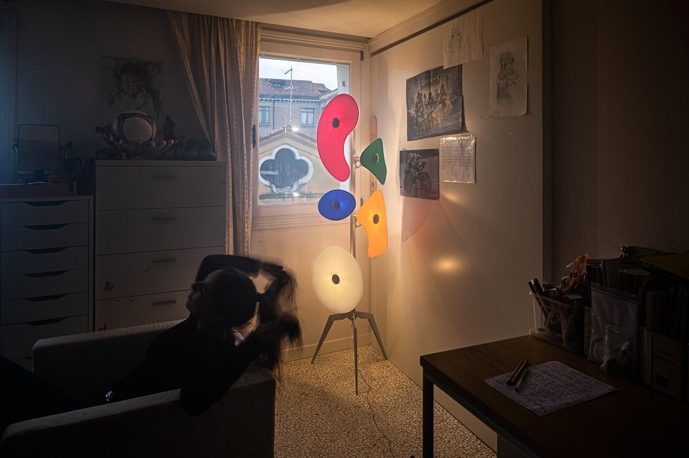 Bunte Stehlampe im Kinderzimmer mit rotem, blauem, gelbem und grünem Lampenschirm, moderne Designerlampe für Wohnraum.