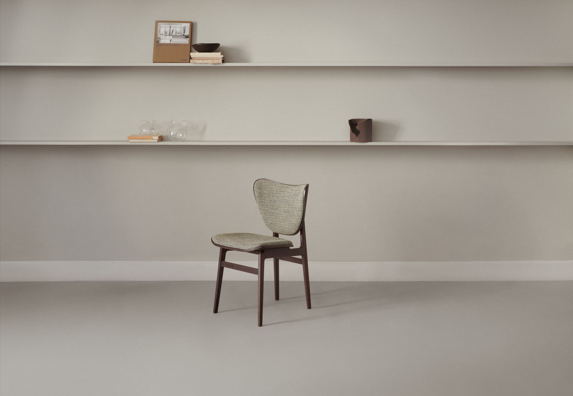 Frontansicht des NORR11 Elephant Dining Chair Stuhls mit Stoffbezug und dunklem Holzgestell.