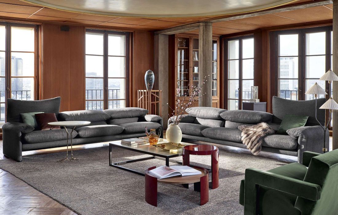 Graues Maralunga Sofa von Cassina, einladendes Wohnzimmer mit Designermöbeln und großen Fenstern.