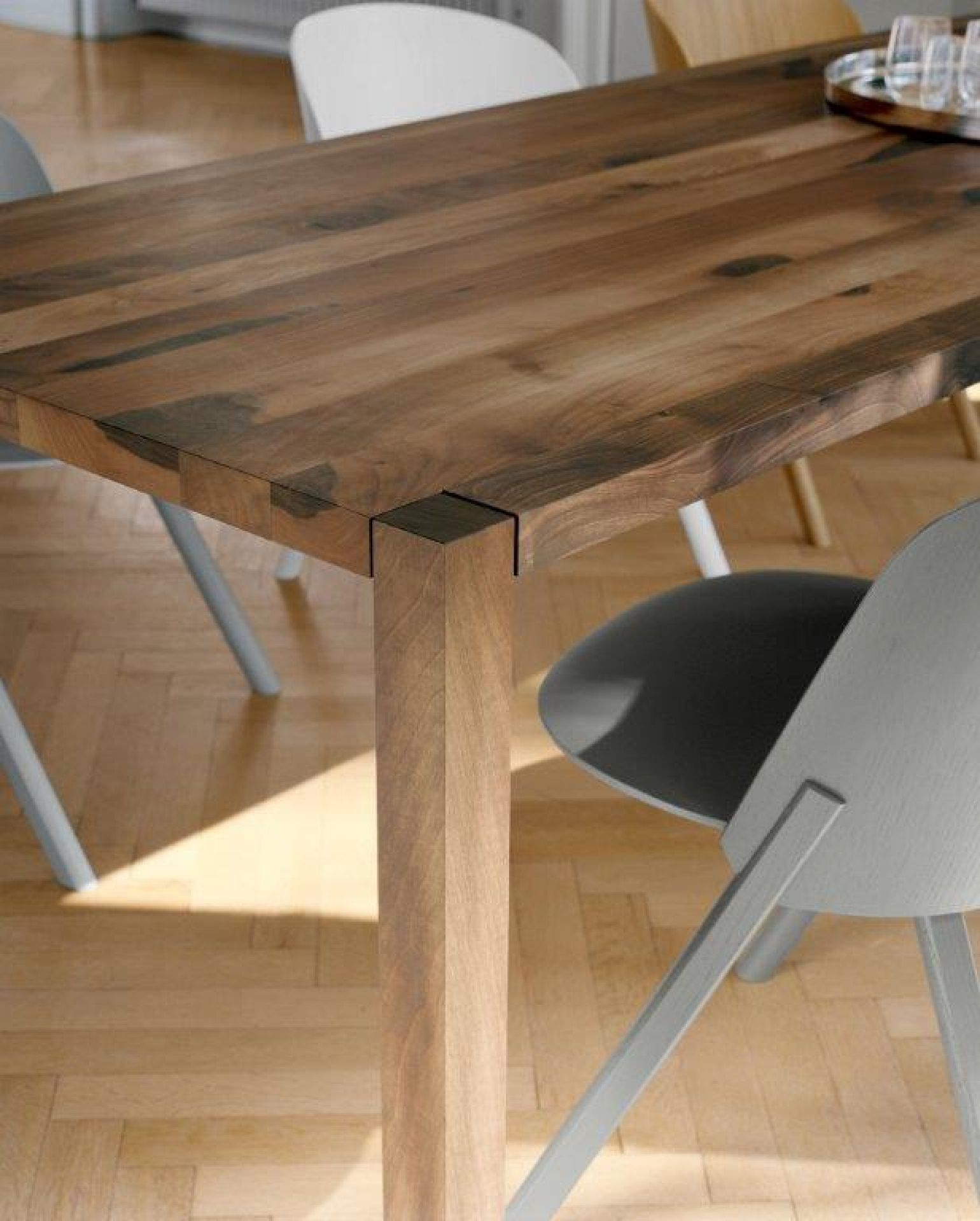Detailansicht des CH05 This Stuhls von e15: Holzstuhl mit grauer Sitzfläche am Esstisch.