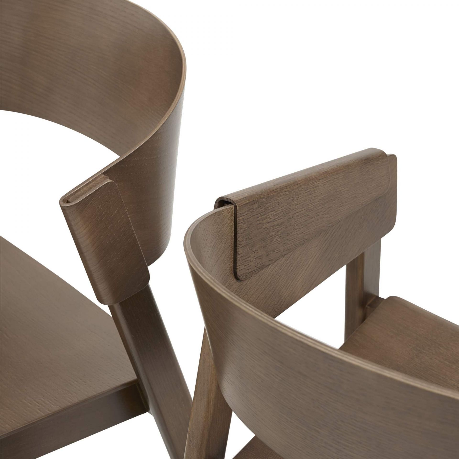 Detailaufnahme von zwei Cover Side Chairs von Muuto, Holzstühle mit geschwungenen Rückenlehnen in brauner Holzoptik.