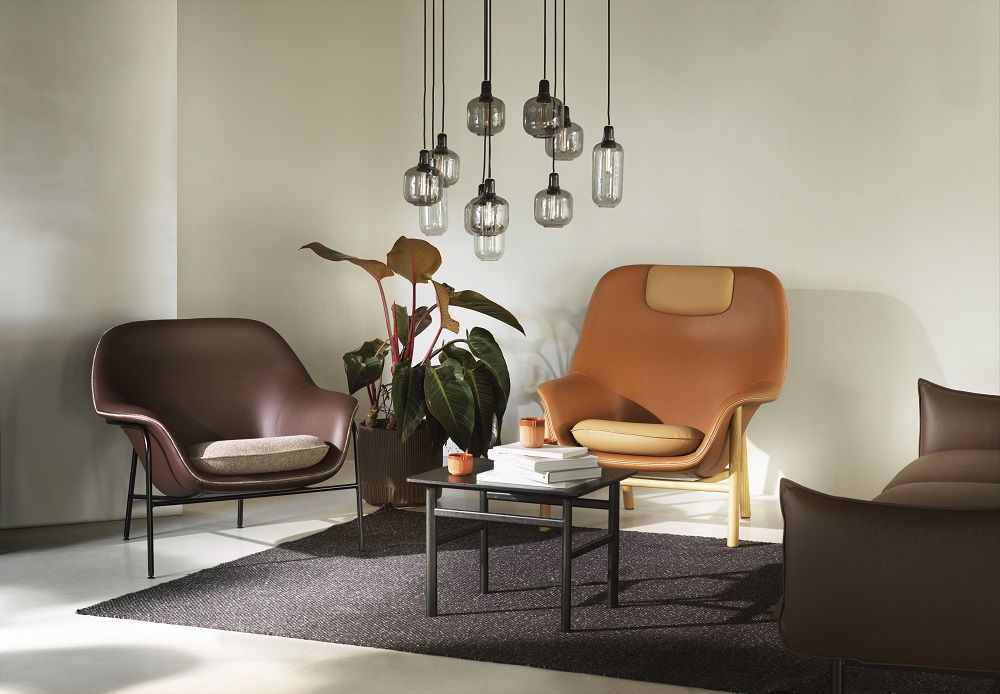 Nahaufnahme eines braunen Lounge Sessels mit Kissen und schwarzem Gestell.