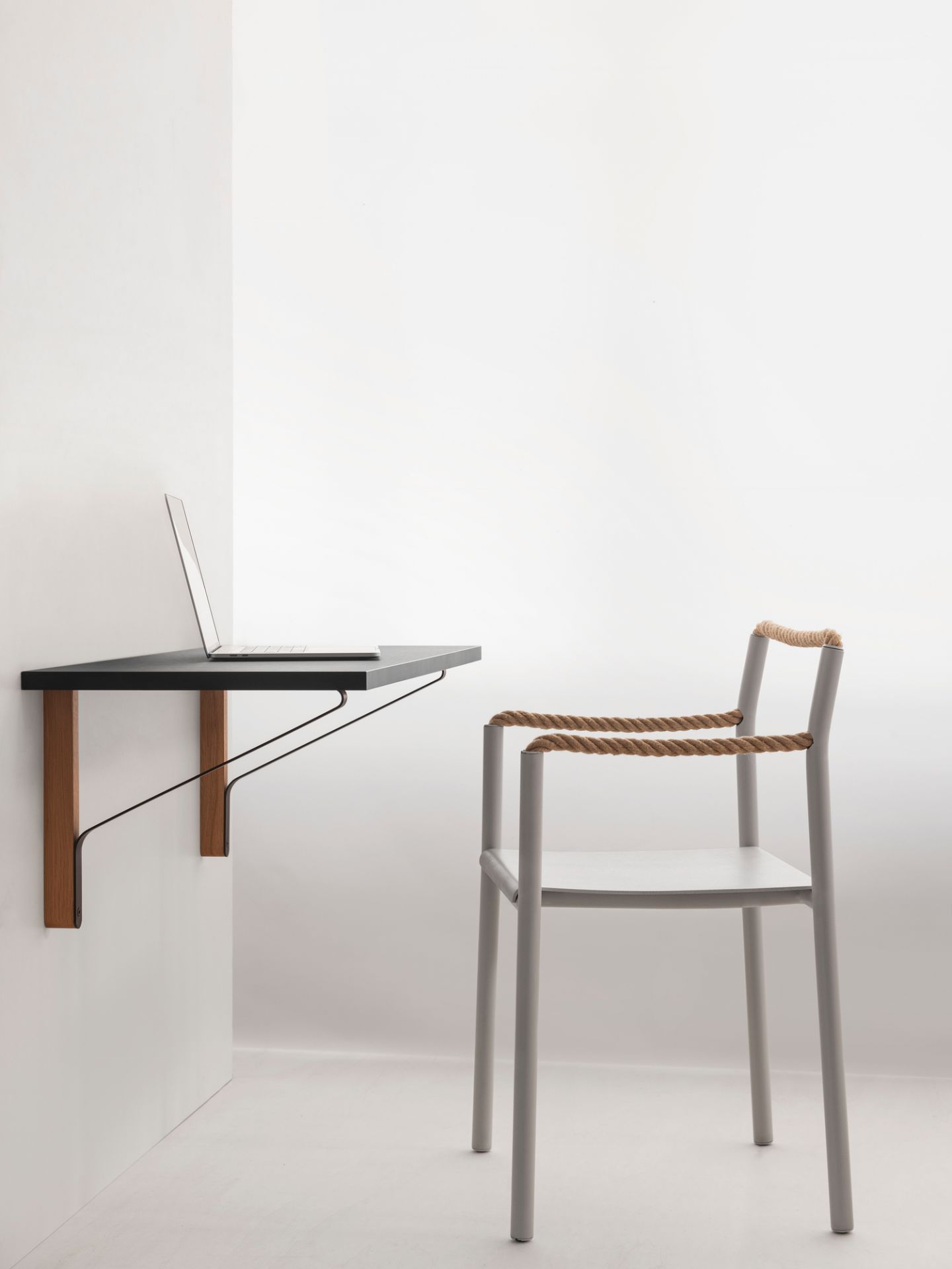Artek Rope Chair Stuhl neben einem an der Wand montierten Schreibtisch mit Laptop in minimalistischem Raum.
