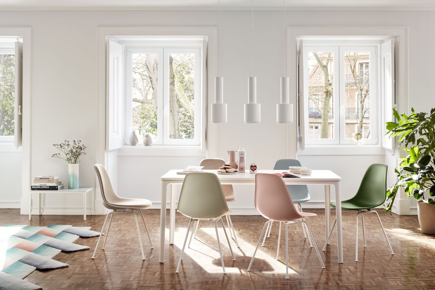 Esszimmer mit Esstisch und farbenfrohen Eames Plastic Side Chairs DSX Stühlen von Vitra.