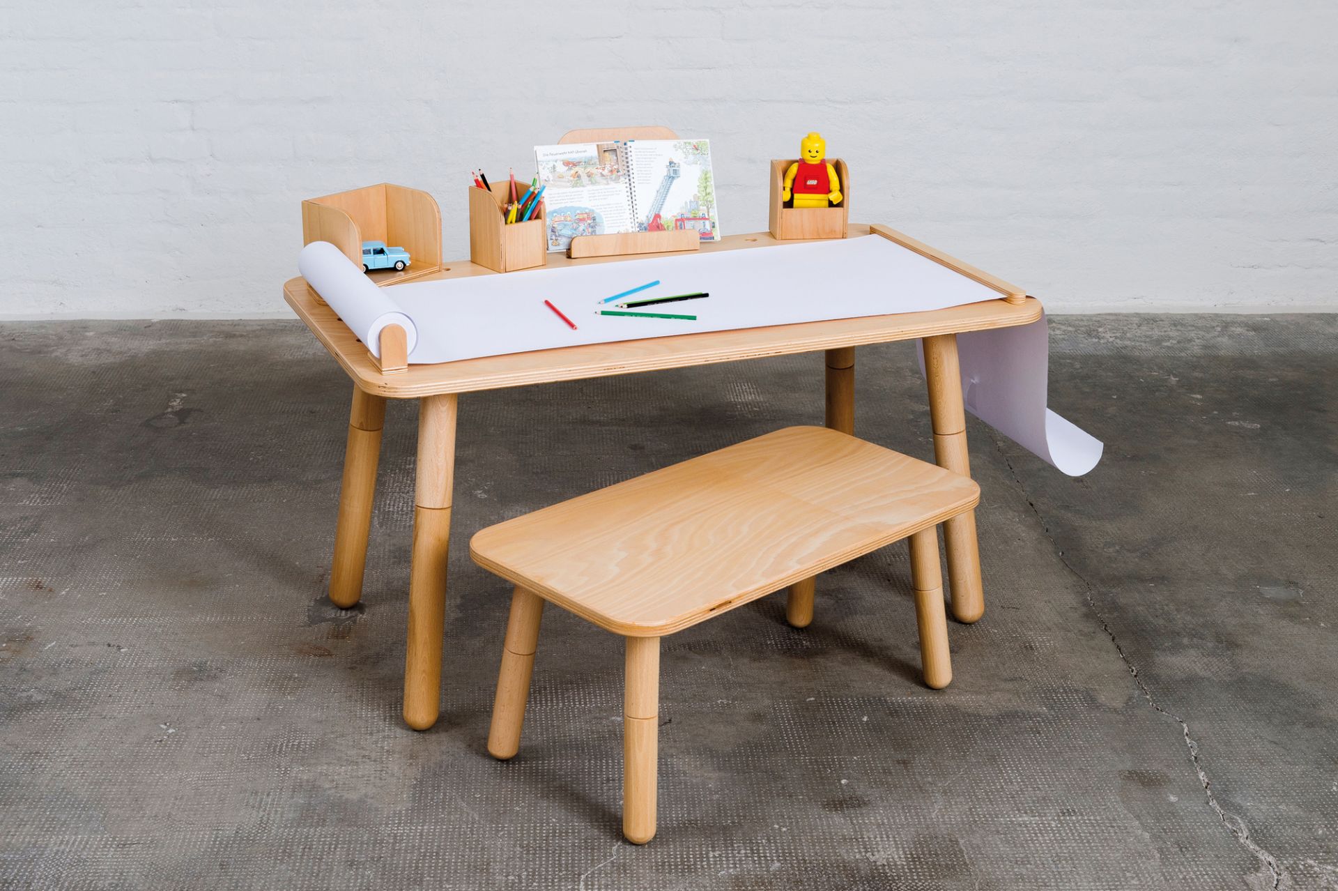 Growing Table Kindertisch aus Buchenholz mit Papierrolle, Stiften und Spielzeug für kreative Kinder.