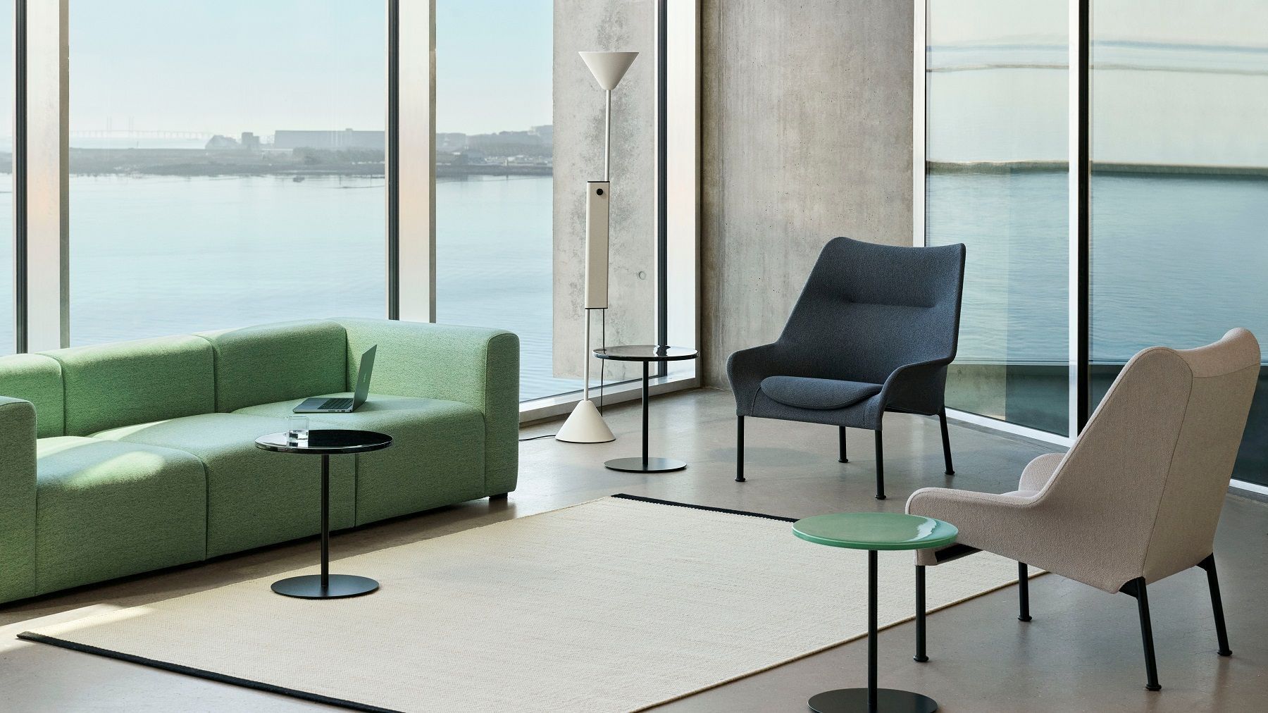 Helle Inneneinrichtung mit Hay Twist Floor Lamp Stehleuchte, Sofa, Sessel, Teppich und Meerblick.