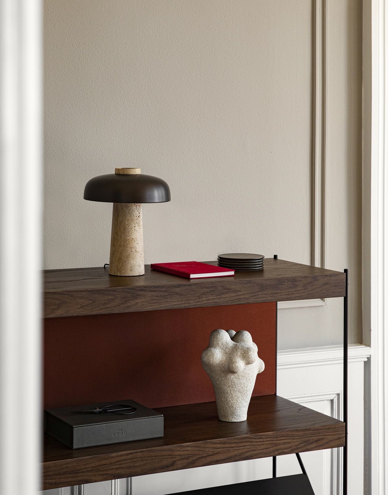 Detailaufnahme des Audo Copenhagen Zet Storage System Regals in dunklem Holz mit Dekorationen.