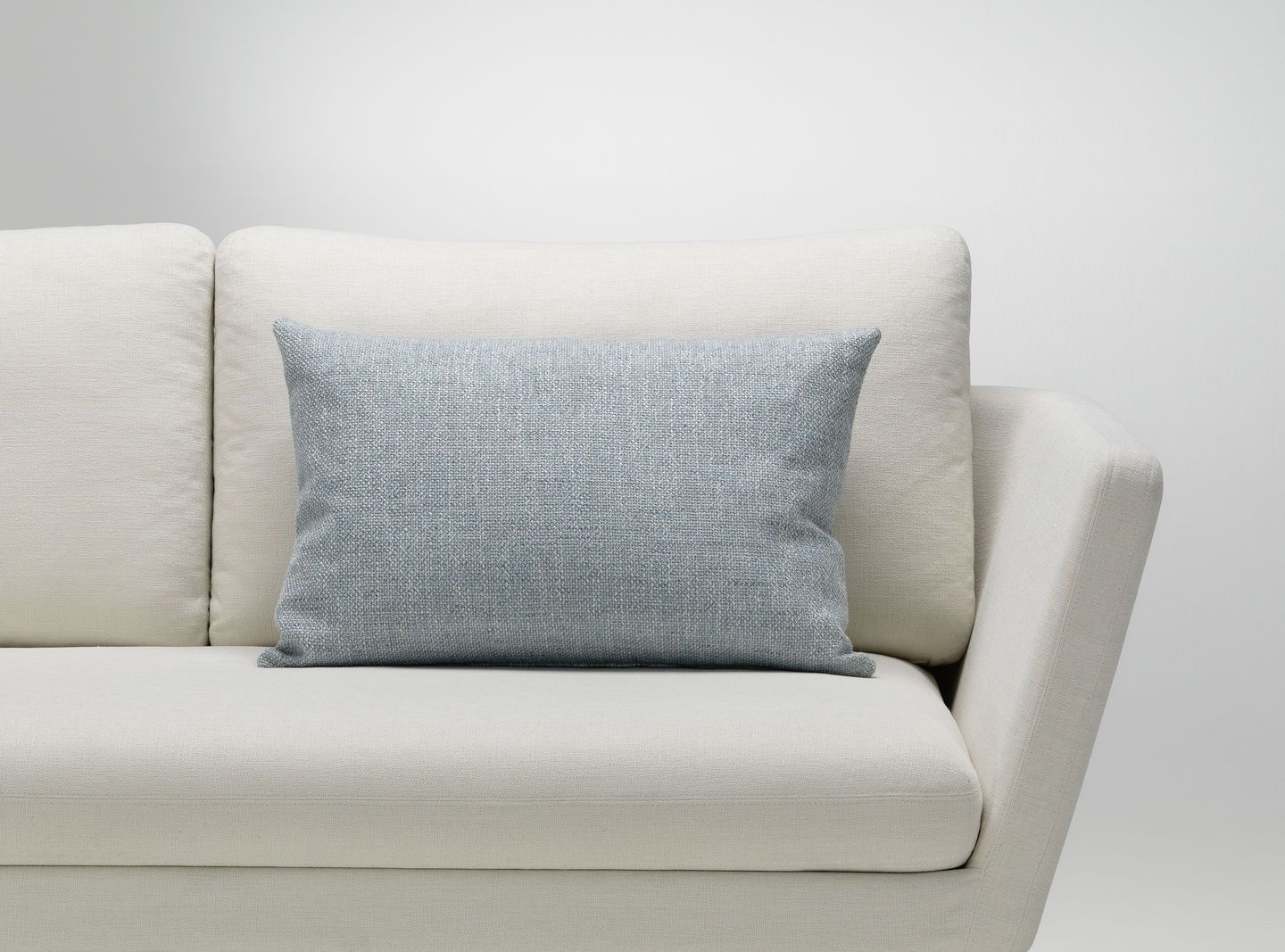 Vitra Kissen in Hellblau auf einem weißen Sofa, Dekokissen für Wohnzimmer und Schlafzimmer.