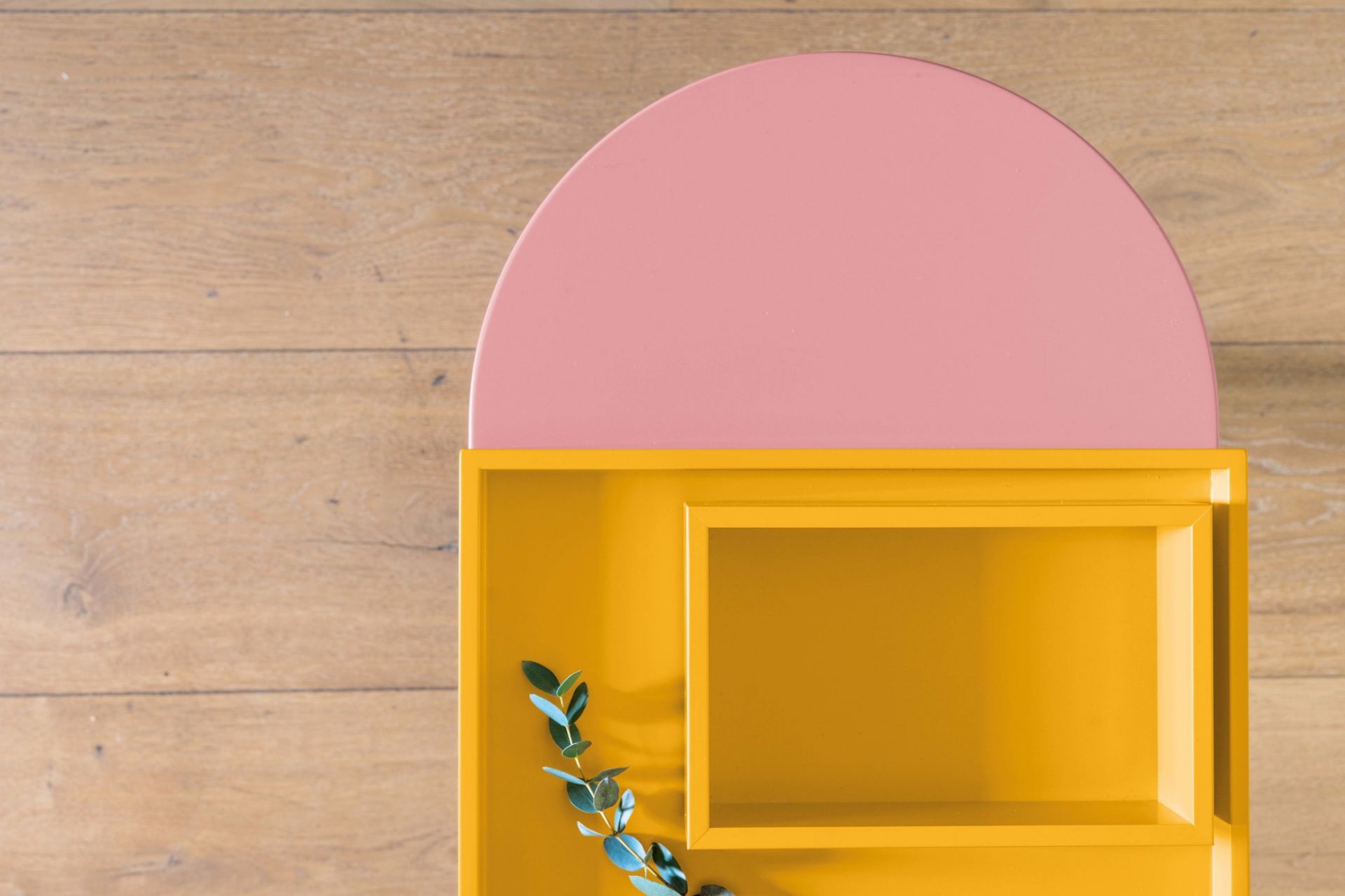 Mala Sitzbank von Schönbuch, gelb und rosa, modernes Möbeldesign mit Holzstruktur im Hintergrund.