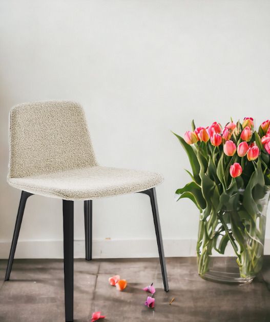 KN07 Stuhl von Knoll International mit beigem Bouclé-Bezug und schwarzen Beinen neben Tulpen.