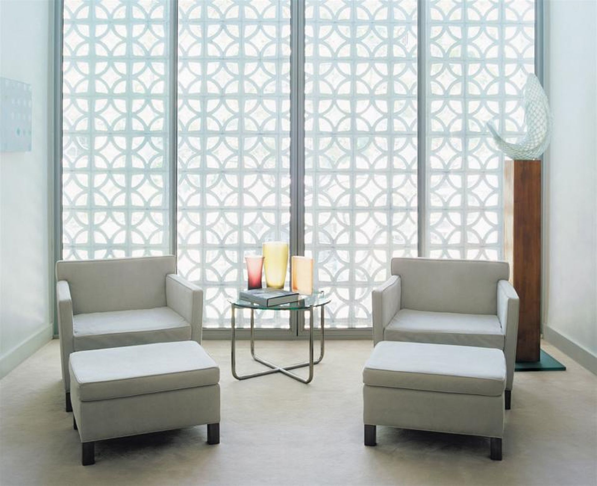 MR Couchtisch von Knoll International mit Glasplatte, Sesseln und Hockern in hellem Raum.