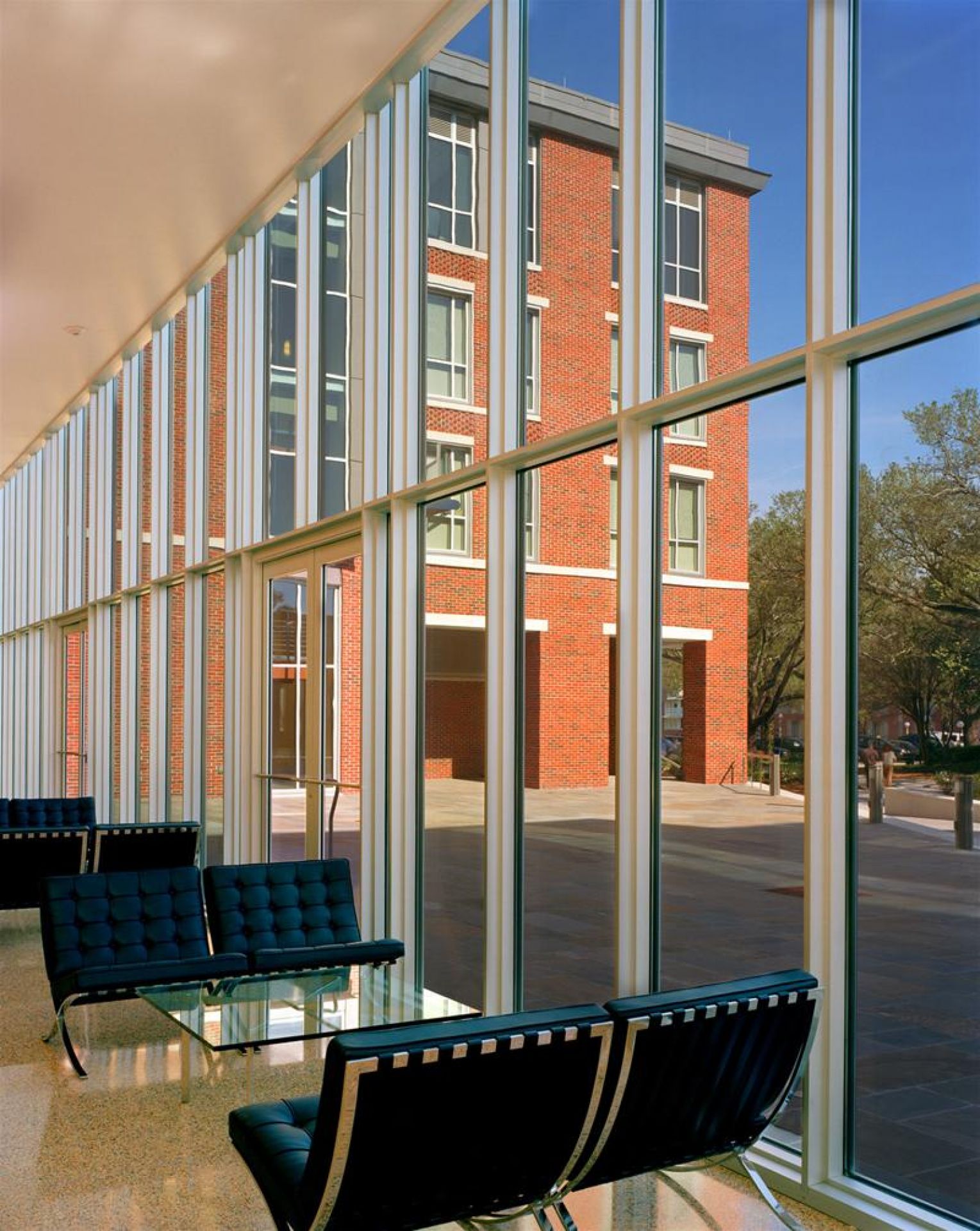 Barcelona Sessel von Knoll International in einem modernen Wartebereich mit Glasfassade und Gebäudeansicht.