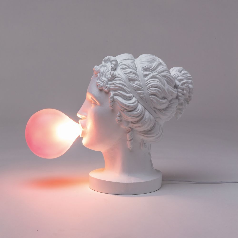 Grace Lamp Tischleuchte von Seletti: Weiße Frauenbüste bläst leuchtende, rosafarbene Kaugummi-Blase als Lampe.