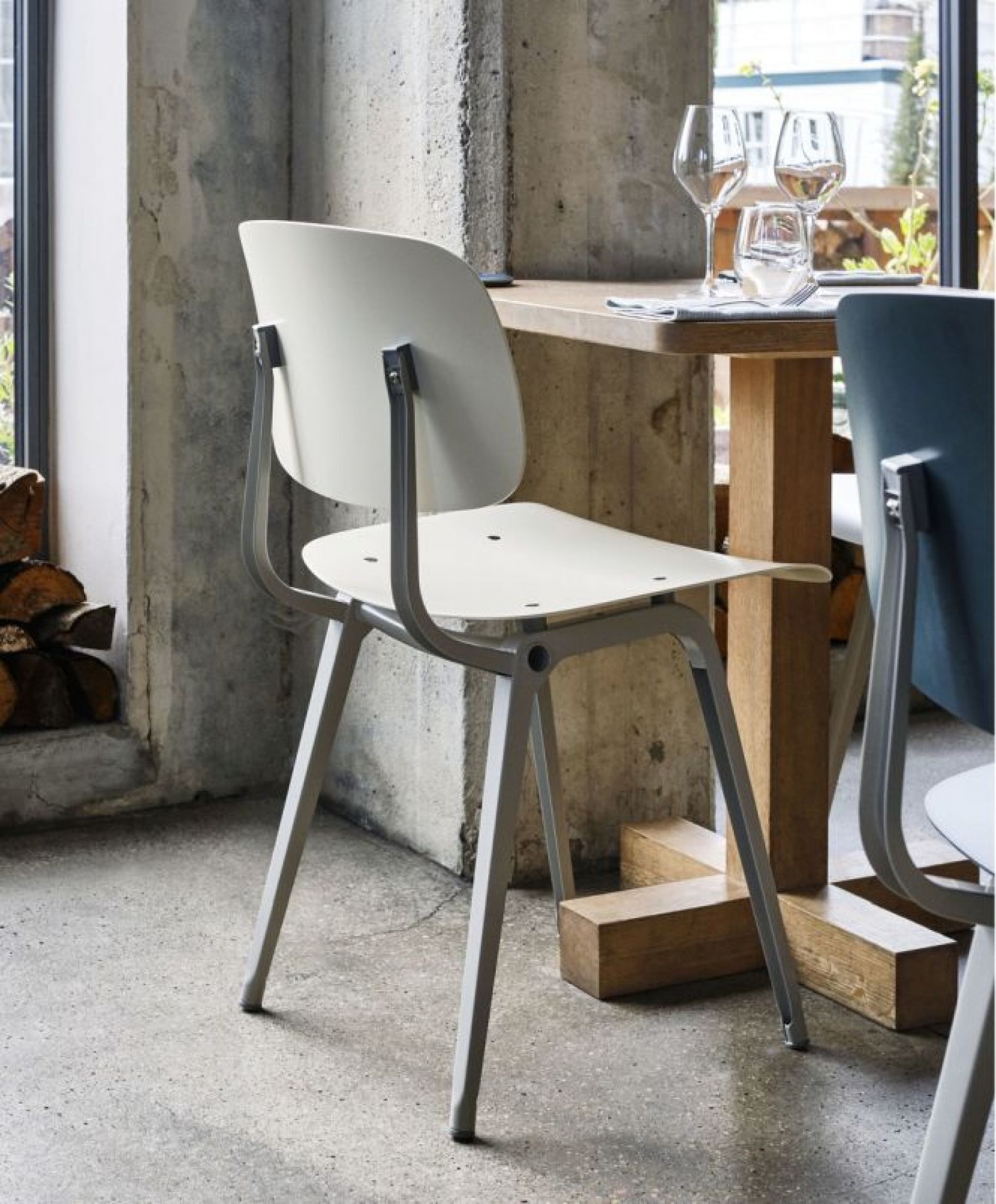 Beiger Revolt Chair Stuhl von Hay mit Stahlgestell in moderner Inneneinrichtung, seitliche Ansicht.