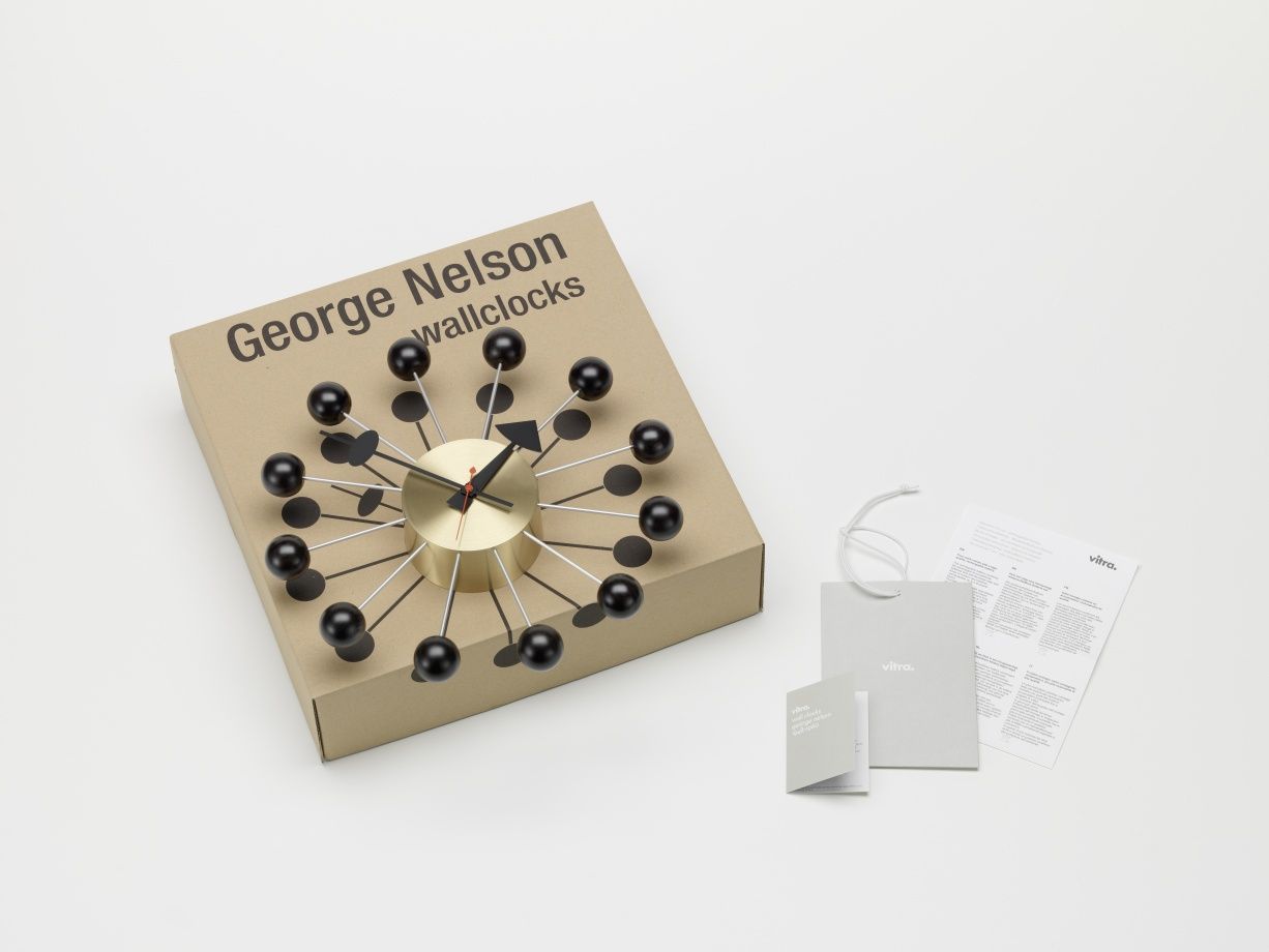 George Nelson Ball Clock Wanduhr in Gold und Schwarz auf Verpackung mit Vitra Zubehör.
