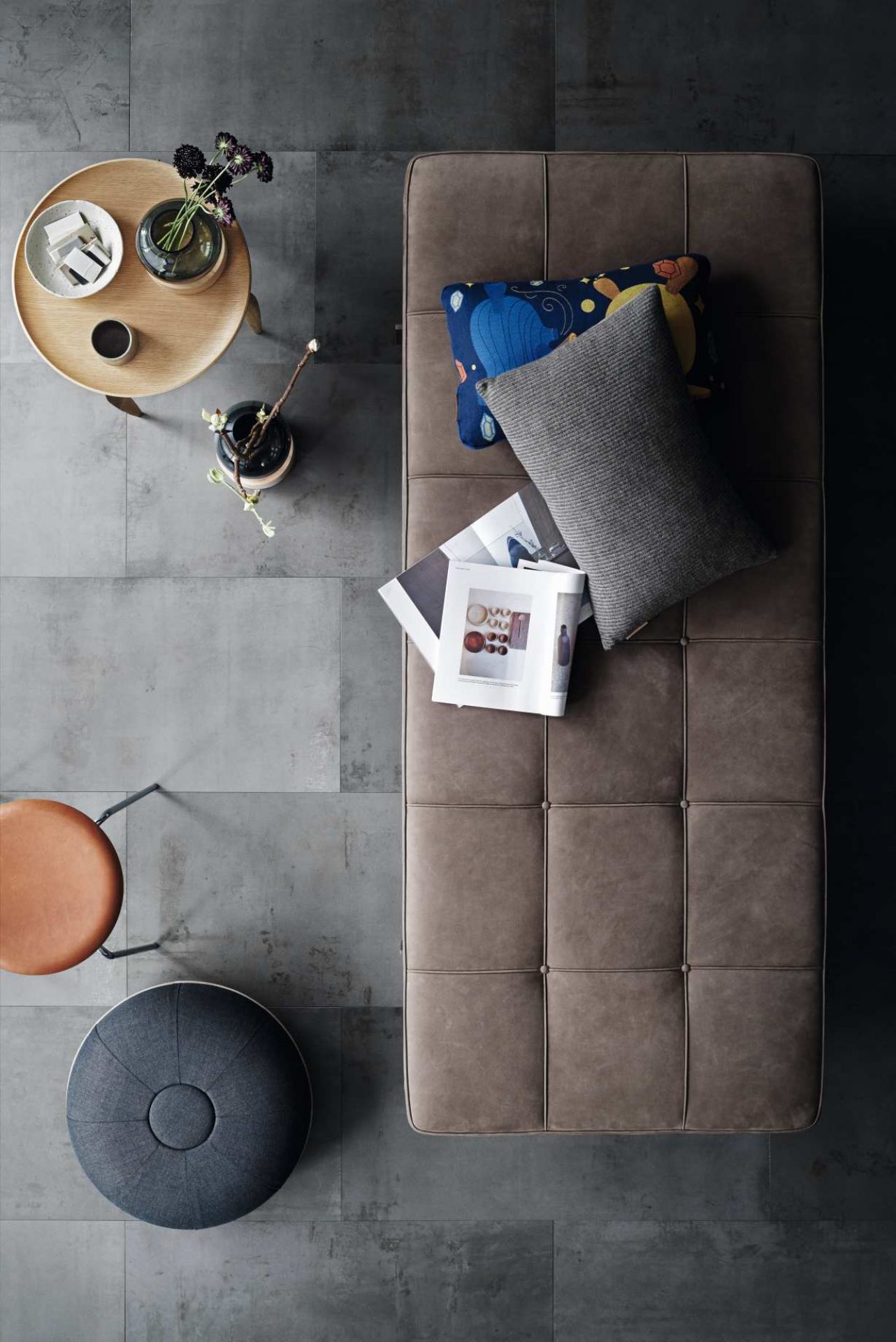 Draufsicht: Elegante PK80 Liege von Fritz Hansen, braunes Leder, Kissen, Zeitschriften und Beistelltisch.