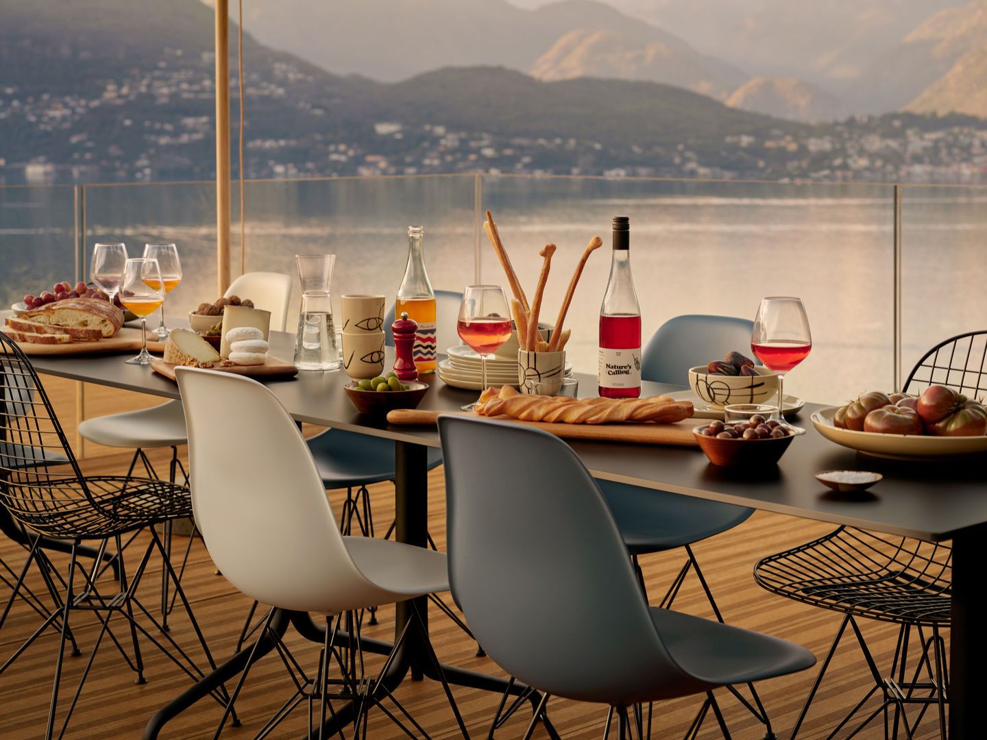 Esstisch mit Speisen und Getränken, umgeben von Eames Plastic Side Chairs DSR von Vitra in verschiedenen Farben.