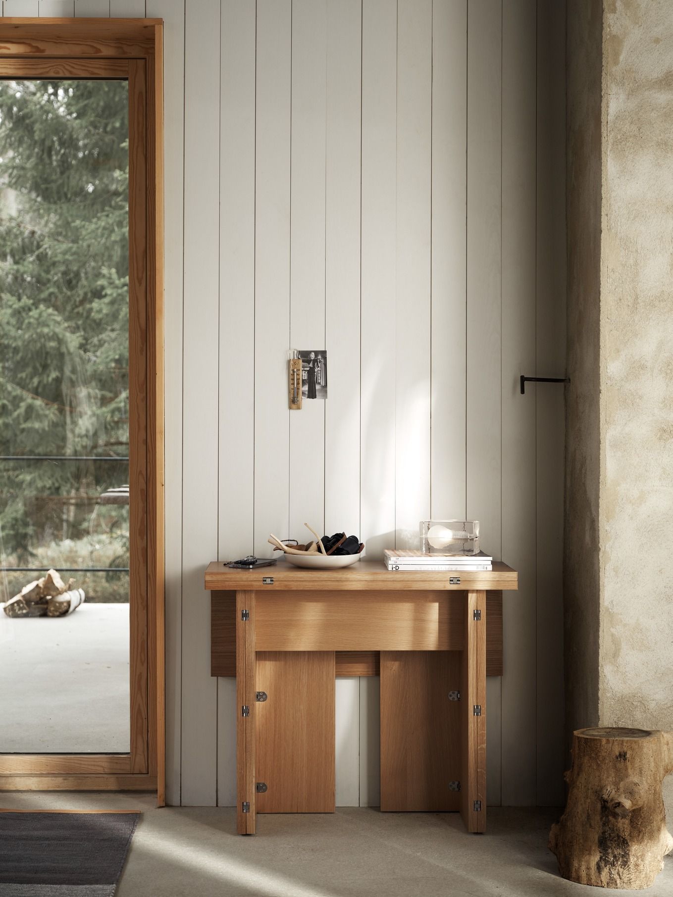 Design House Stockholm Flip Table Klapptisch aus Eichenholz, halb ausgeklappt, mit Deko-Elementen in modernem Interieur.