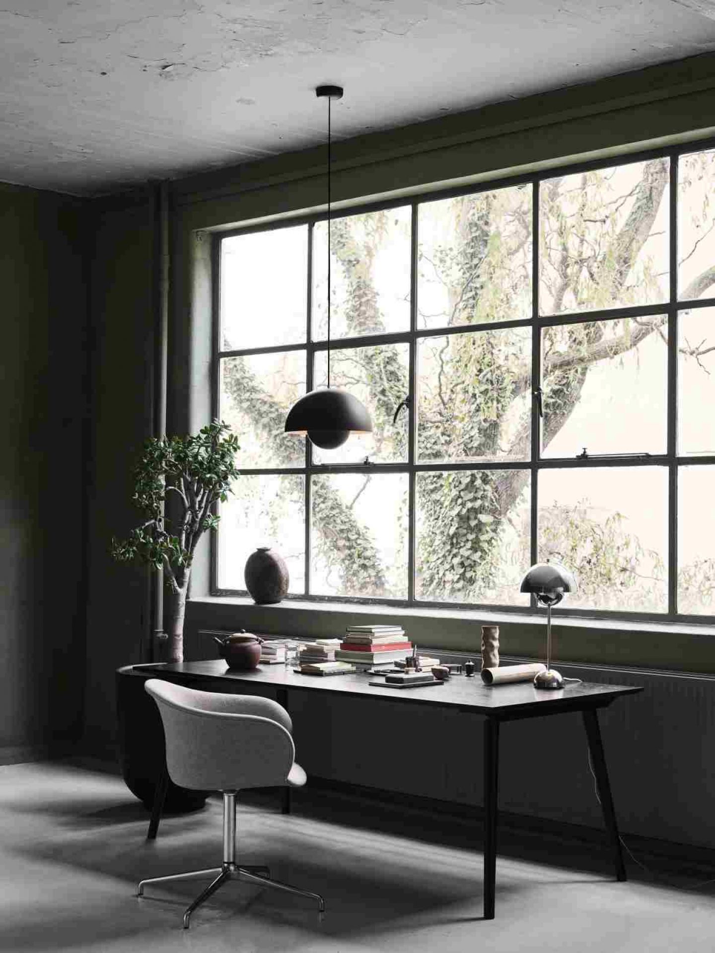 AndTradition In Between Table SK5 aus Holz in dunklem Arbeitszimmer mit großem Fenster.