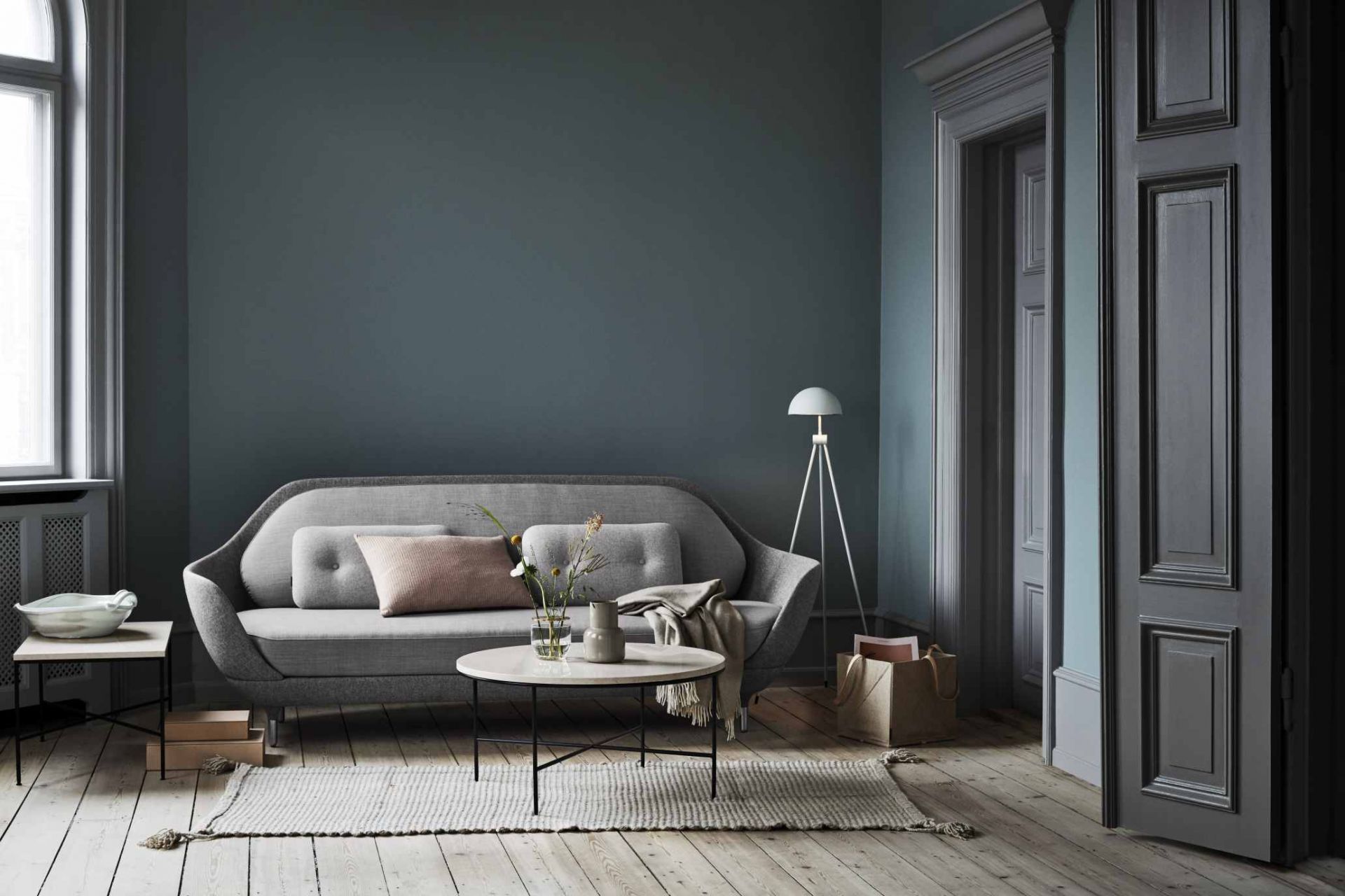 Wohnzimmer mit grauem Sofa und Fritz Hansen Planner Couchtisch mit Marmorplatte und schwarzem Metallgestell.