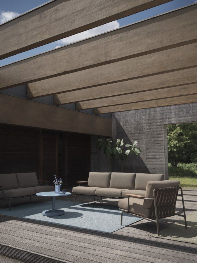 Muuto Settle Outdoor Sofa: Moderne Gartenmöbel-Gruppe mit 2-Sitzer Sofa, Sessel und Tisch auf Holzterrasse.