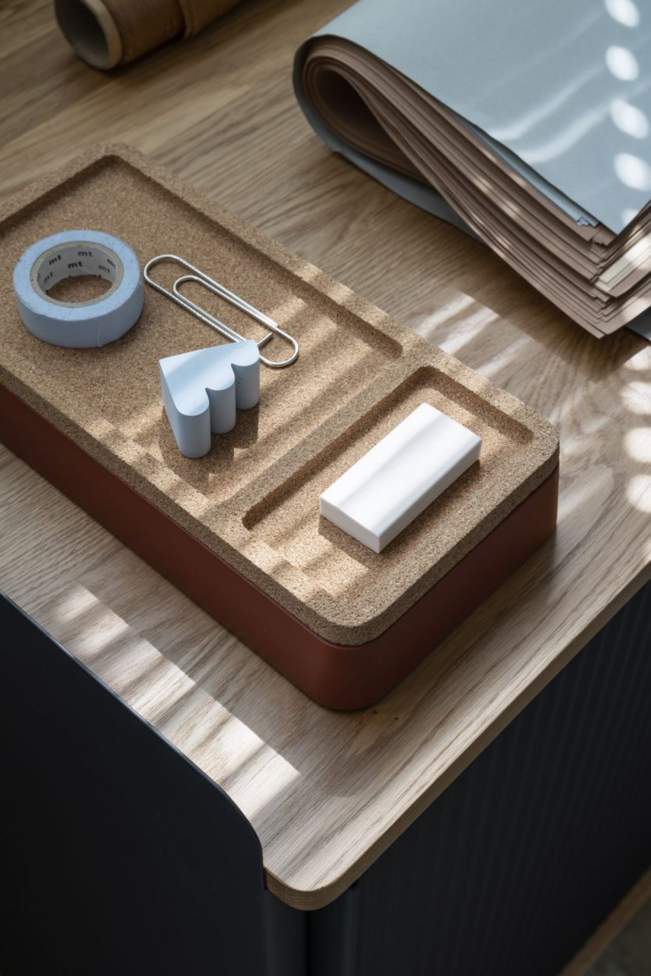 Muuto Arrange Desktop Serie Konfiguration 1: Schreibtisch-Organizer aus Kork mit Büroartikeln wie Klebeband und Radiergummi.