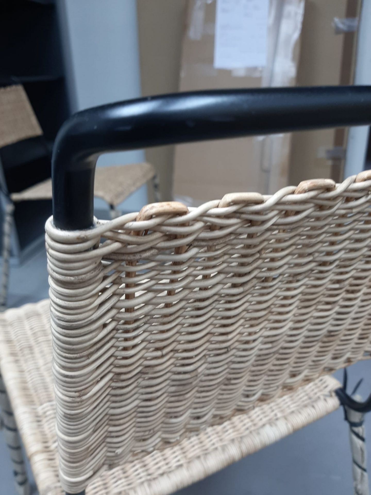 Detailaufnahme des Stuhls TT 54 von Richard Lampert, ein Rattanstuhl mit schwarzem Metallgestell, Mängelexemplar.
