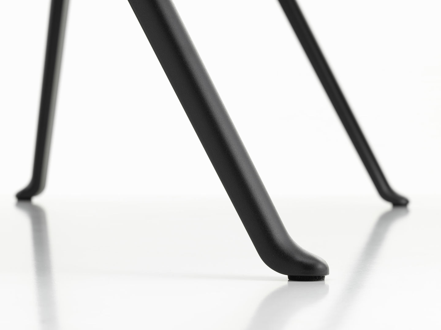 Detailaufnahme der schwarzen Beine des Vitra Courier Schreibtischs mit Fokus auf die Füße und deren Beschaffenheit.