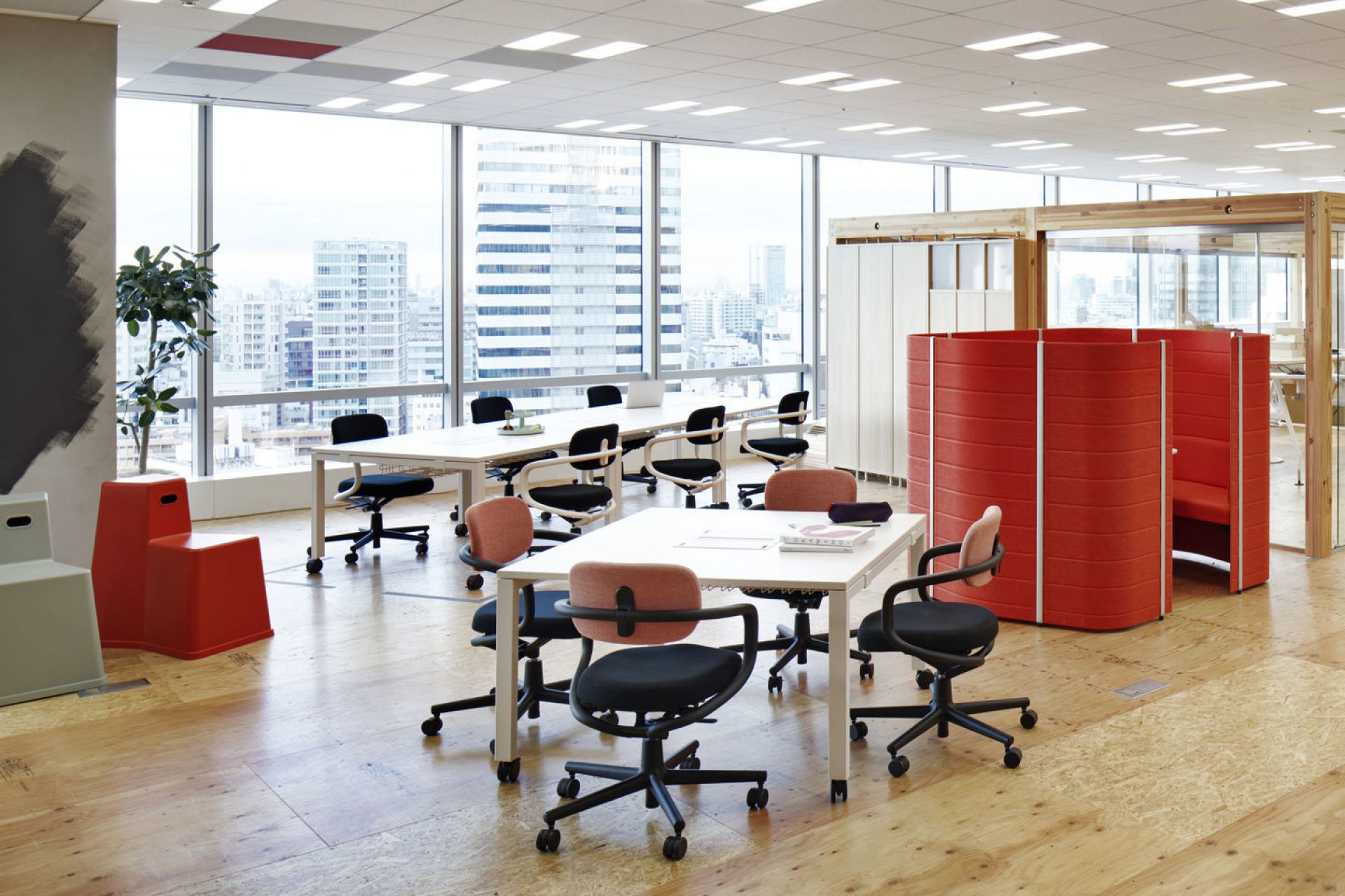 Helles Büro mit mehreren Allstar Bürodrehstühlen von Vitra in Schwarz und Rosé um weiße Tische.