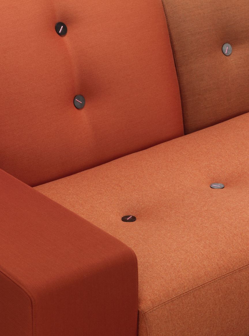Detailaufnahme des orangefarbenen Polder Sofa von Vitra mit Knopfheftung, ein modernes Designmöbel für Wohnzimmer.