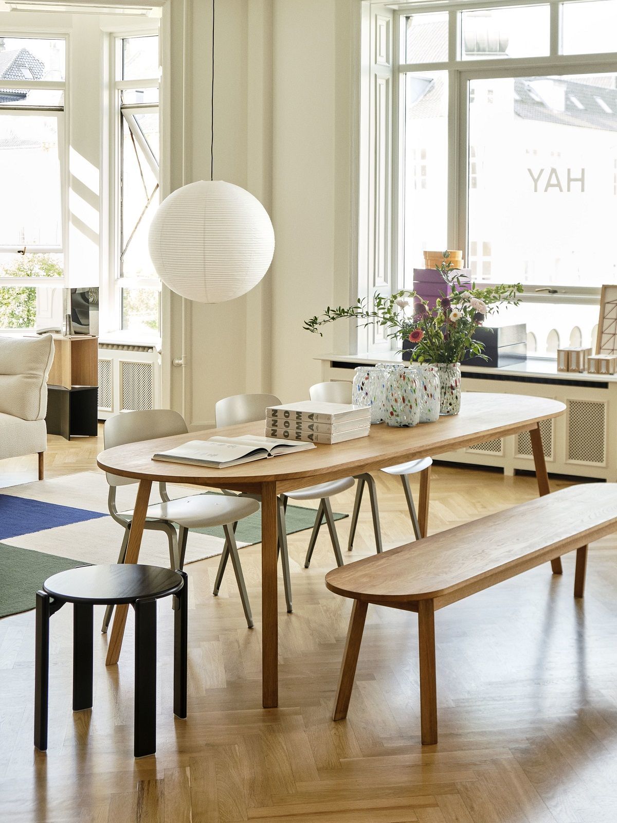 Heller Essbereich mit ovalem Triangle Leg Table Esstisch von Hay, Stühlen, Bank und Dekoration.