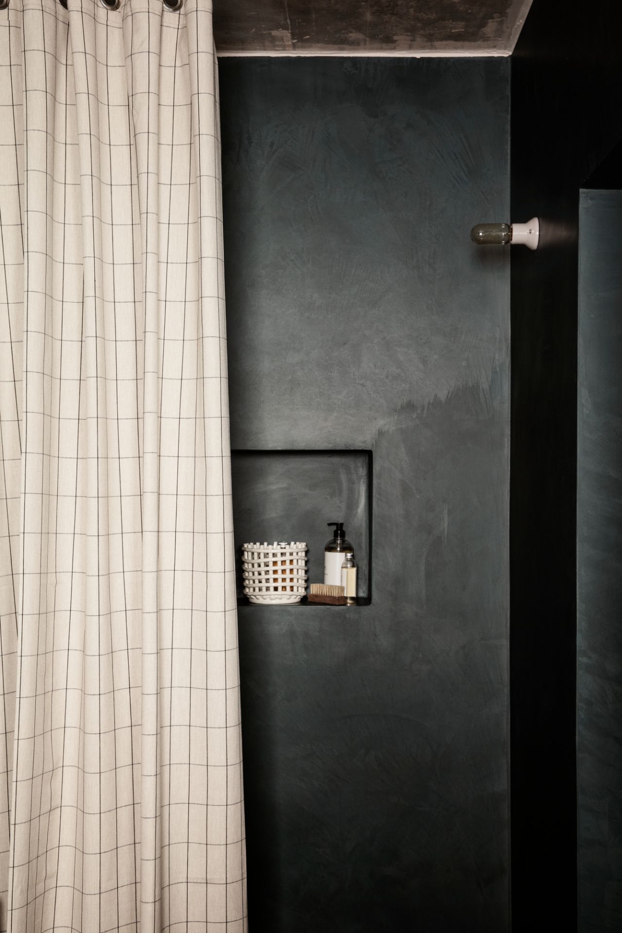 Großer, weißer Keramikkorb von Ferm Living im Badezimmerregal, neben Seife und Bürste.