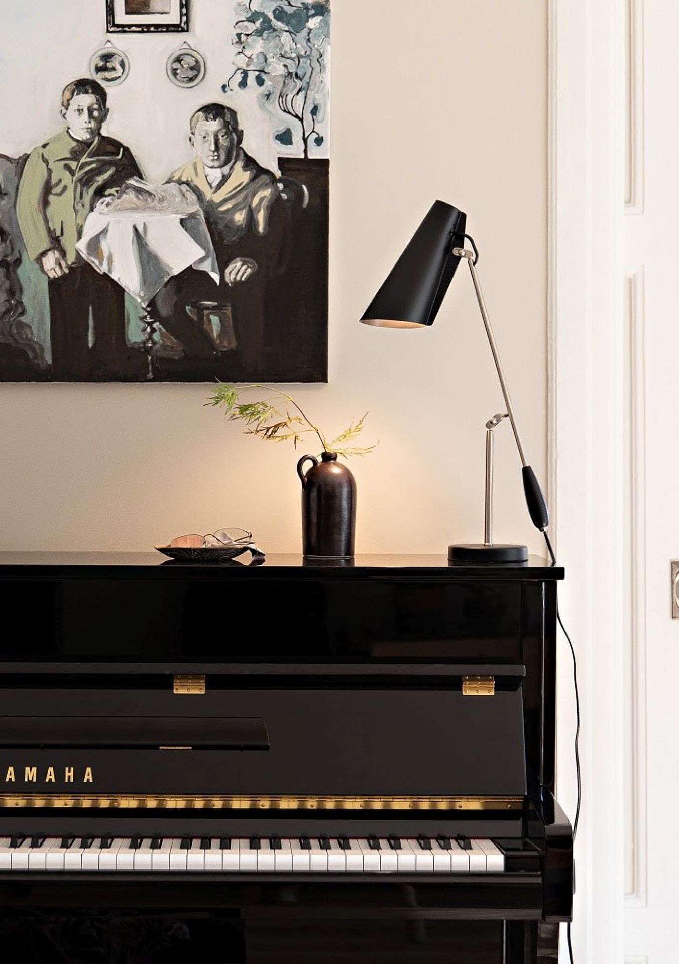 Schwarze Birdy Tischleuchte von Northern auf einem Klavier, modernes Design für Wohnzimmer und Büro.