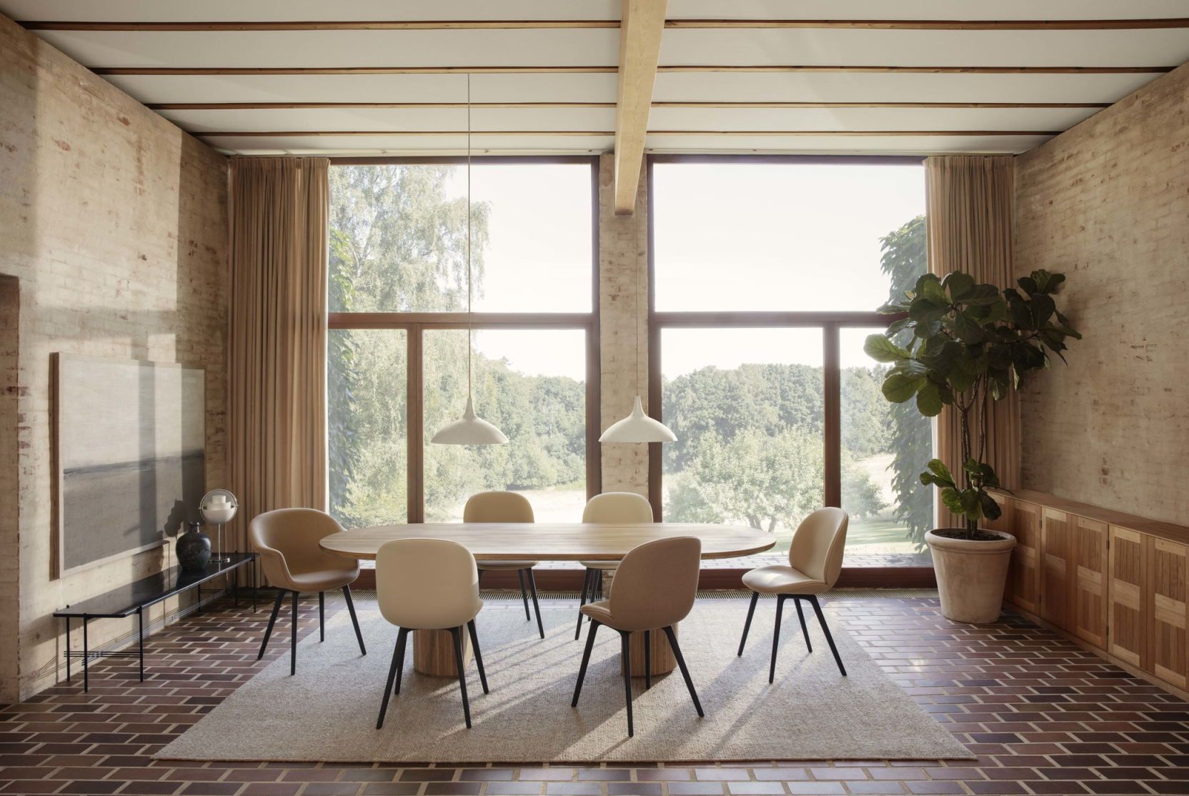 Esszimmer mit ovalem Tisch, Stühlen und zwei weißen 1965 Pendelleuchten von Gubi.