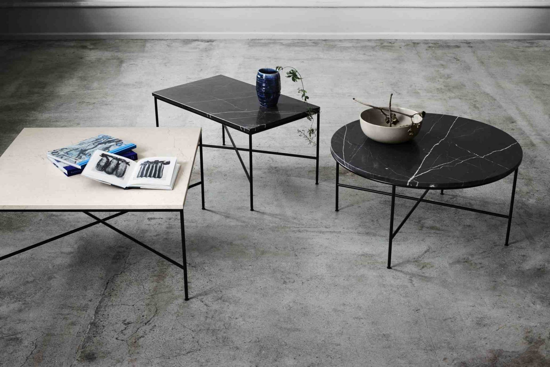 Fritz Hansen Planner Couchtisch-Set: Quadratischer Tisch mit Büchern, rechteckiger Tisch mit Vase, runder Tisch mit Schale.