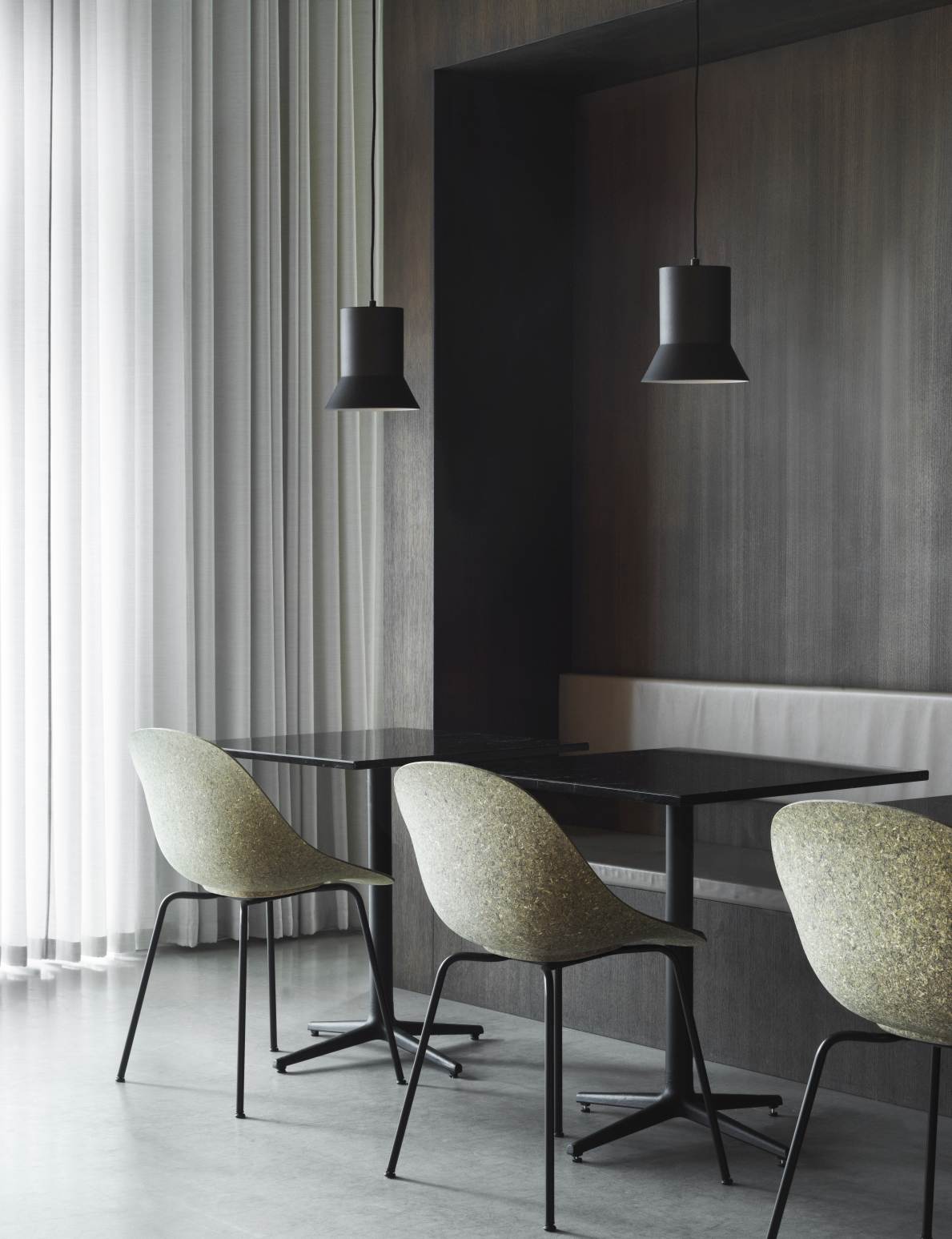 Normann Copenhagen Mat Chair Steel Stuhl in Beige mit schwarzem Stahlgestell an Esstisch.