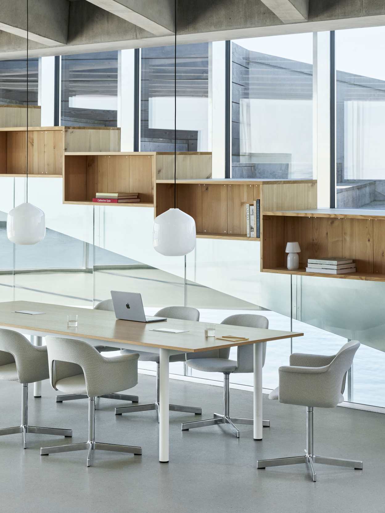 Annex Table Overhang Esstisch von Hay in einem modernen Büro mit Stühlen und Laptop.