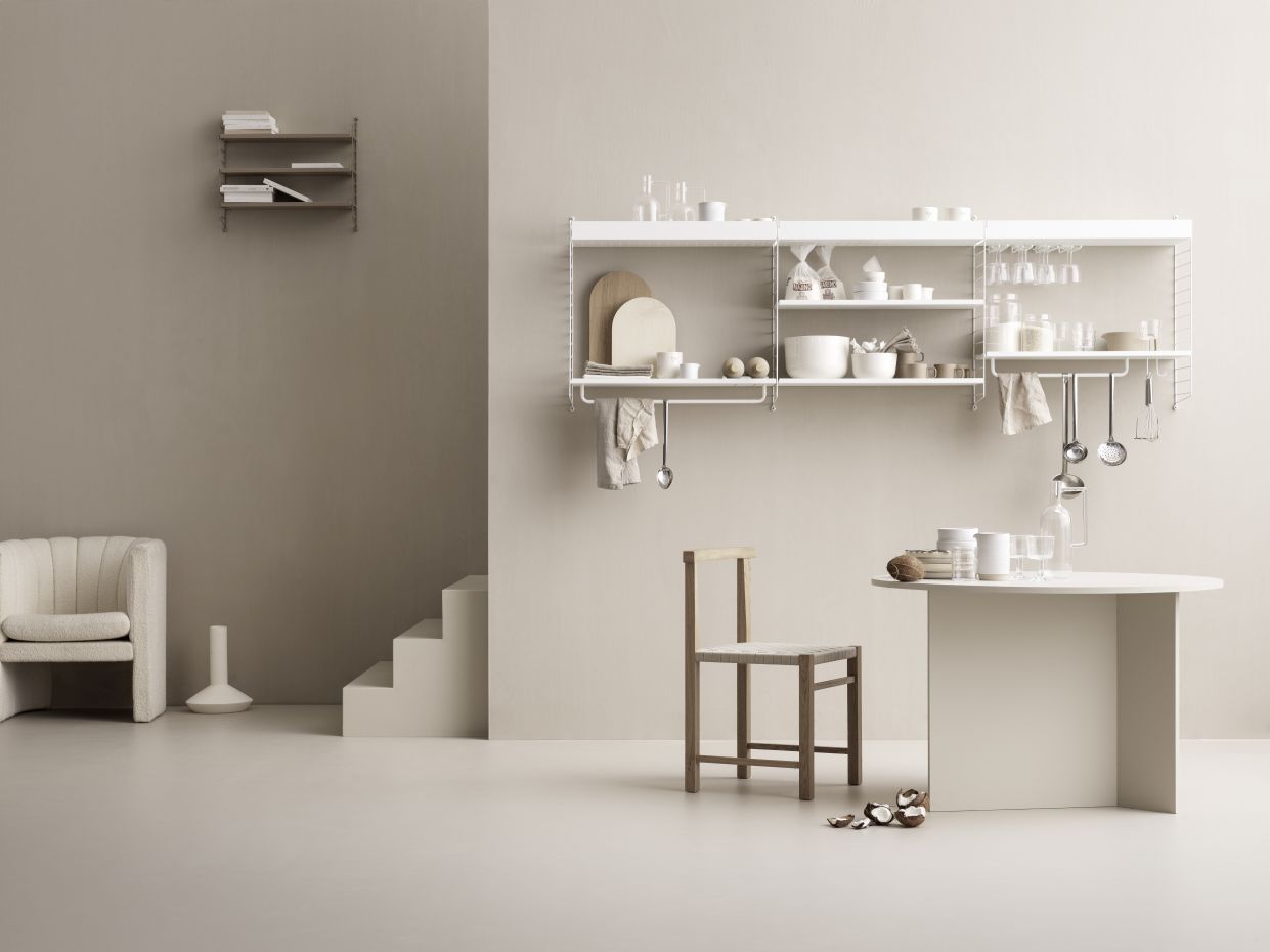 Minimalistisches Interieur mit String Furniture Regalsystem und schwarzer Wandleiter. Skandinavisches Design für Wohnzimmer oder Küche.