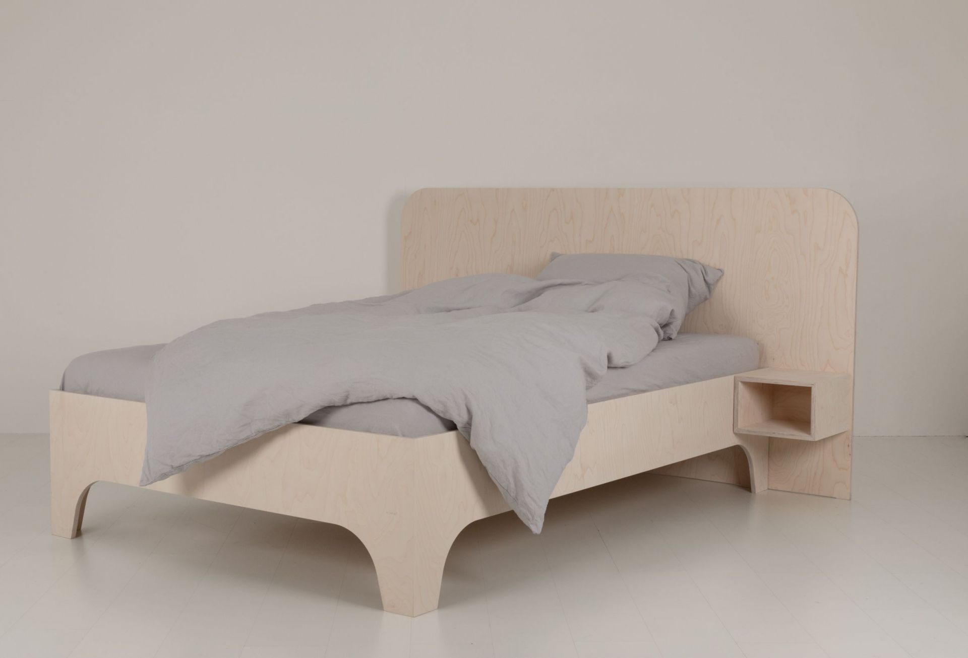 VALENTINA Bett 180x200 cm aus hellem Holz mit grauem Bettbezug und integriertem Nachttisch.